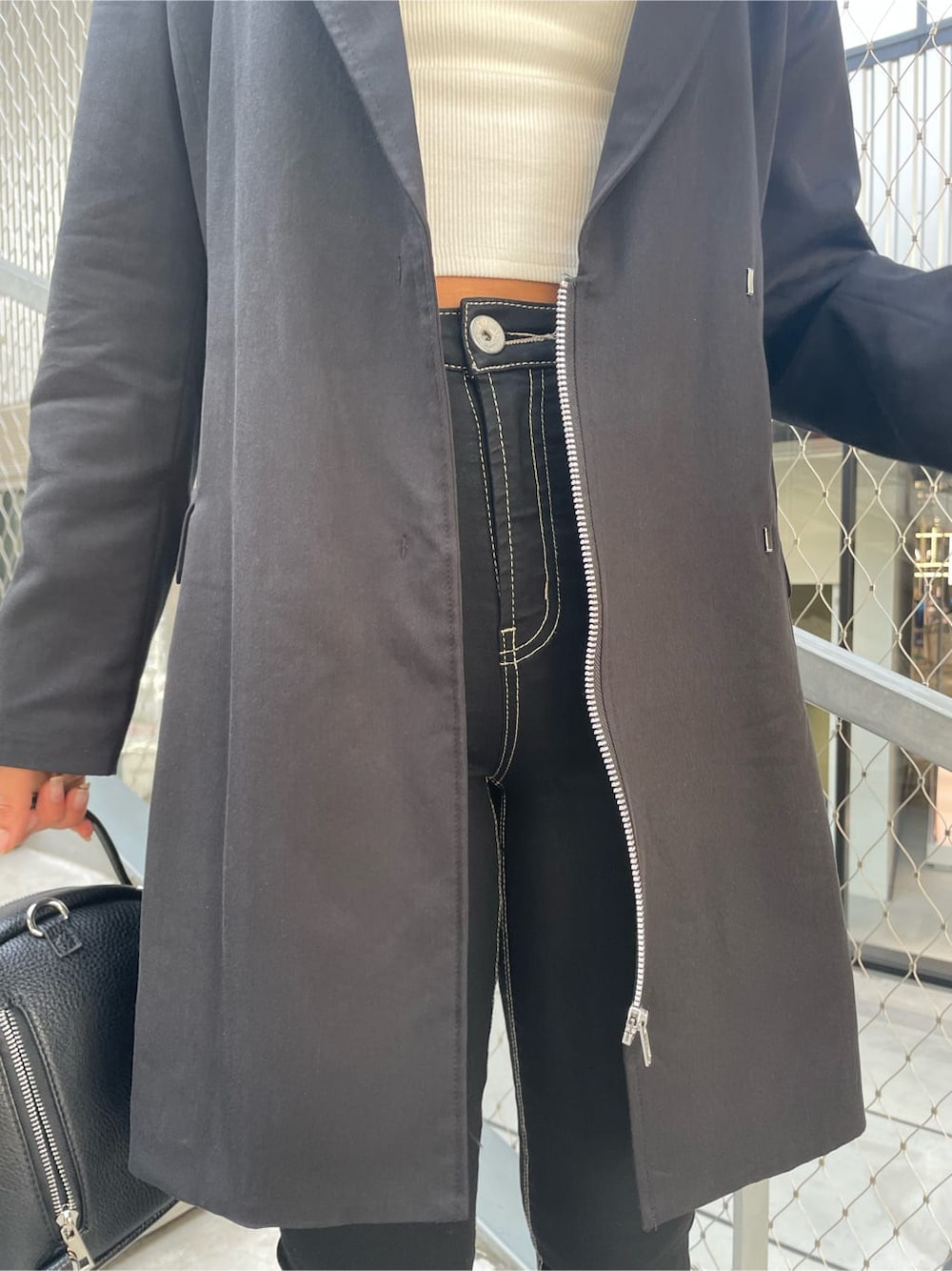 ホワイト系のチューブトップ、ブラック系のパンプス、ブラック系のデニムパンツを着用したレディースの春コーディネートの10枚目の写真