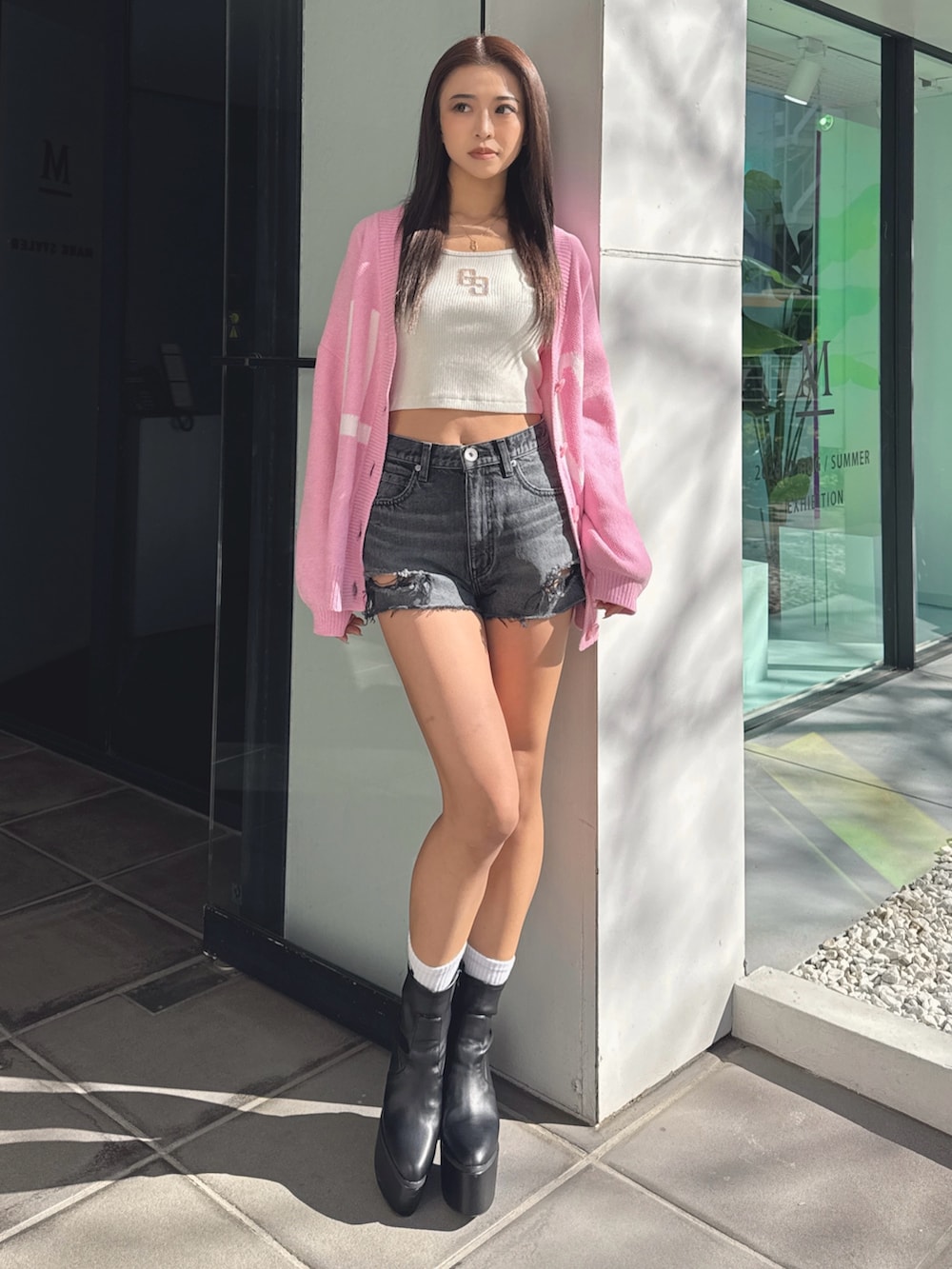 ホワイト系のTシャツ/カットソー、ピンク系のカーディガン/ボレロ、ブラック系のデニムパンツを着用したレディースの春コーディネートの2枚目の写真