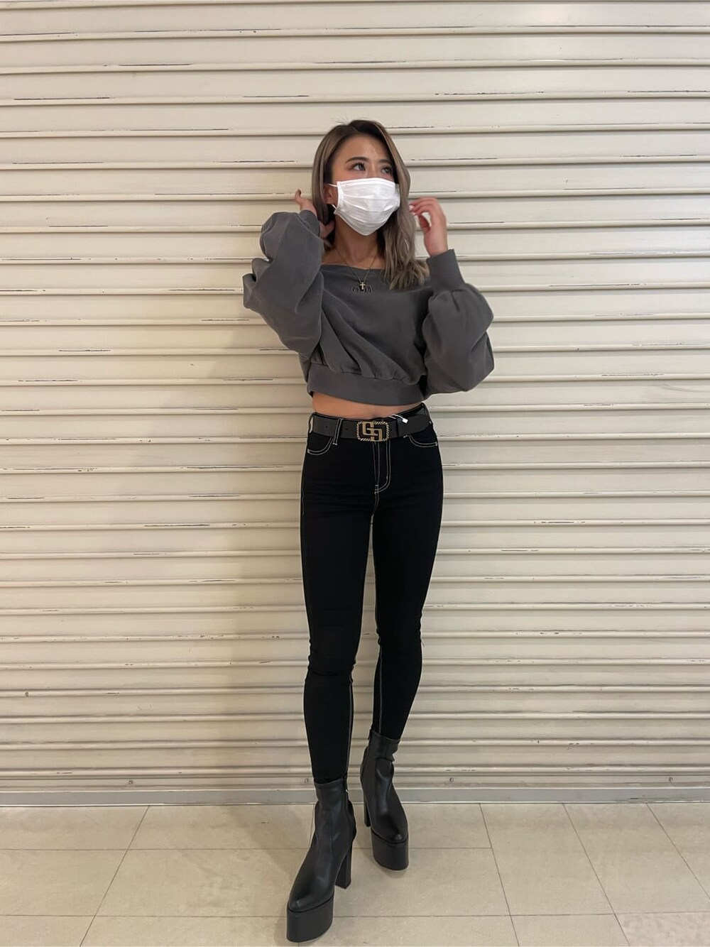 ブラック系のデニムパンツ、グレー系のスウェット、ブラック系のブーツを着用したレディースの秋コーディネートの3枚目の写真