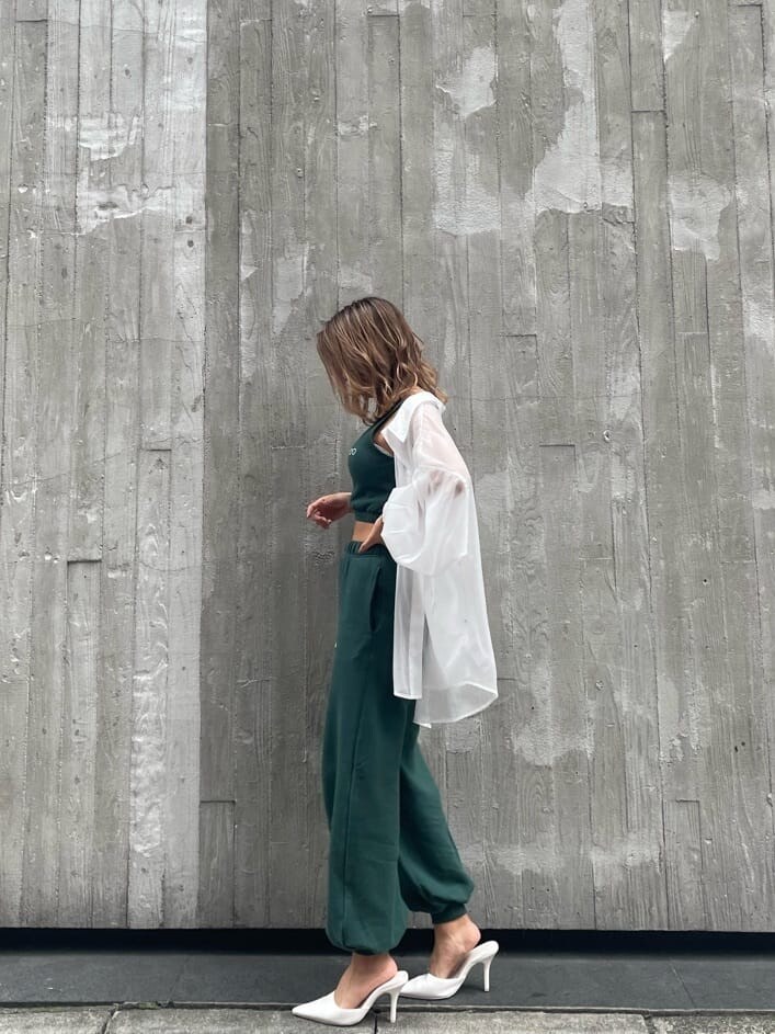 ブラック系のショルダーバッグ、ホワイト系のシャツ/ブラウス、グリーン系のスウェットパンツを着用したレディースの春コーディネートの3枚目の写真