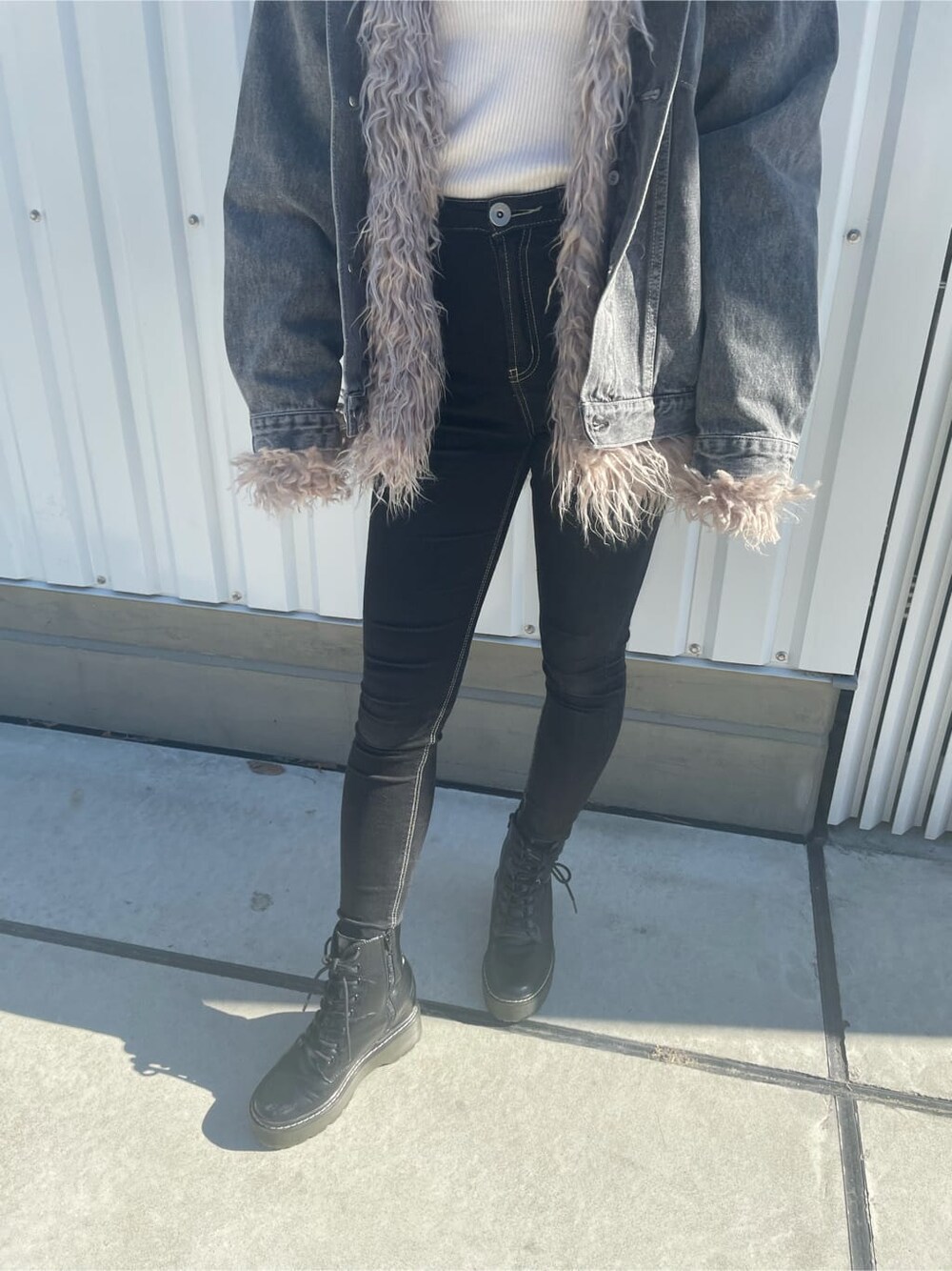 ブラック系のブーツ、ブラック系のデニムパンツ、ホワイト系のニット/セーターを着用したレディースの秋コーディネートの7枚目の写真