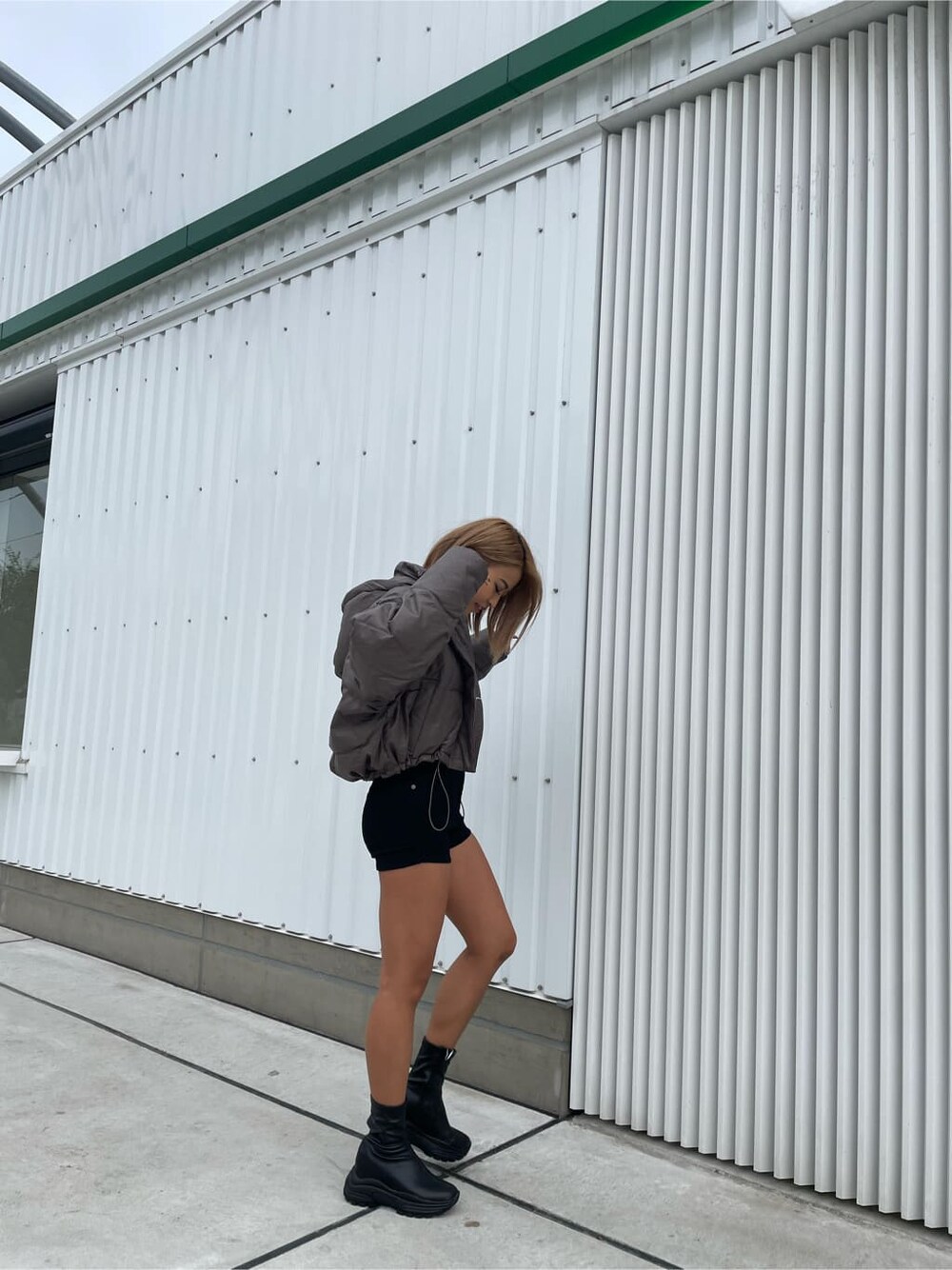 ベージュ系のダウンジャケット/コート、ブラック系のデニムパンツ、ブラック系のブーツを着用したレディースの秋コーディネートの2枚目の写真