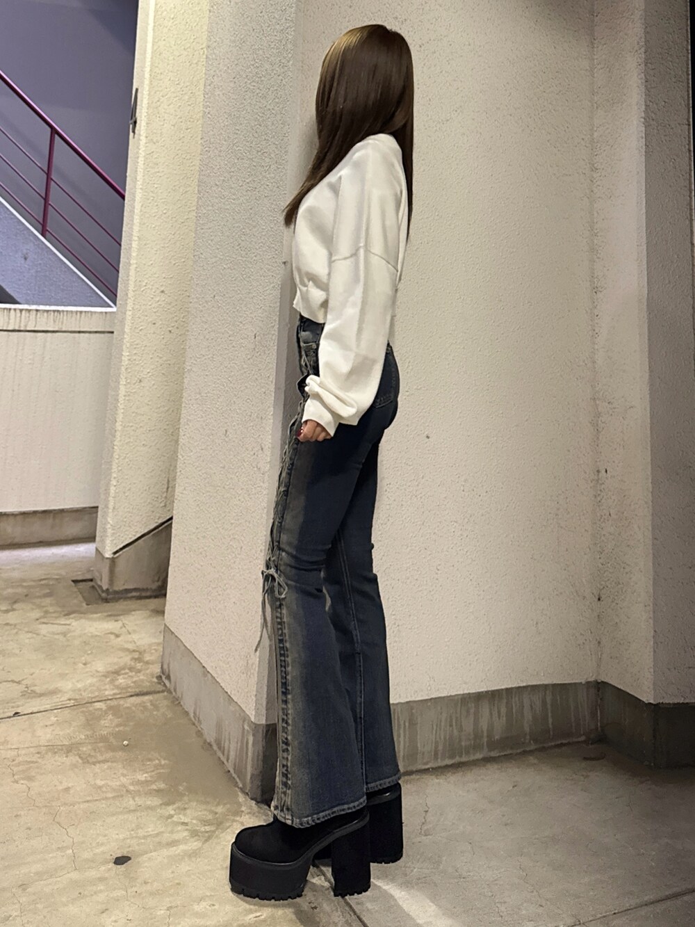 ホワイト系のニット/セーター、ブルー系のデニムパンツ、ブラック系のブーツを着用したレディースの秋コーディネートの2枚目の写真