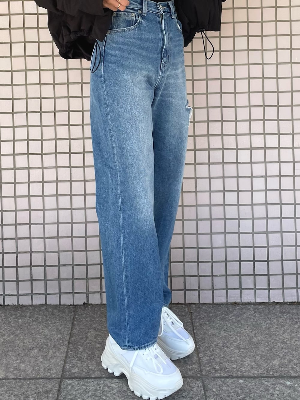 ホワイト系のスニーカー、ブルー系のデニムパンツ、ブラック系のニット/セーターを着用したレディースの冬コーディネートの9枚目の写真