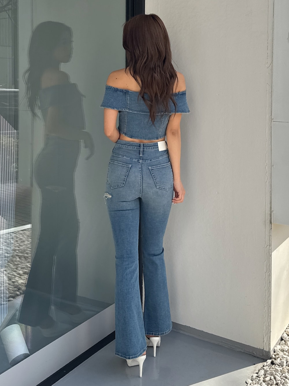 ブルー系のTシャツ/カットソー、ブルー系のデニムパンツ、ホワイト系のパンプスを着用したレディースの冬コーディネートの4枚目の写真