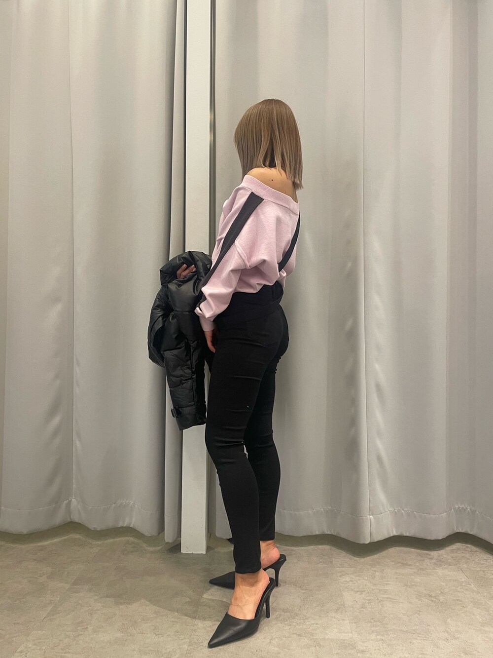 ブラック系のサロペット/オーバーオール、ピンク系のニット/セーター、ブラック系のダウンジャケット/コートを着用したレディースの冬コーディネートの6枚目の写真