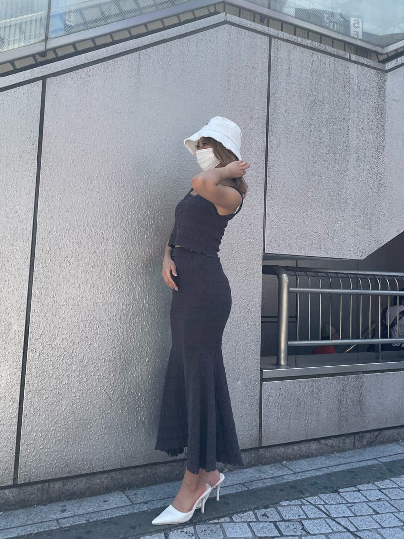 ホワイト系のパンプス、グレー系のスカート、グレー系のタンクトップを着用したレディースの夏コーディネートの2枚目の写真