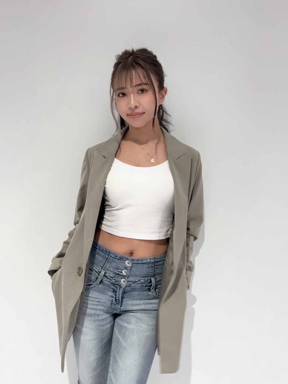 ベージュ系のテーラードジャケット、ブルー系のデニムパンツ、ホワイト系のパンプスを着用したレディースの春コーディネートの6枚目の写真