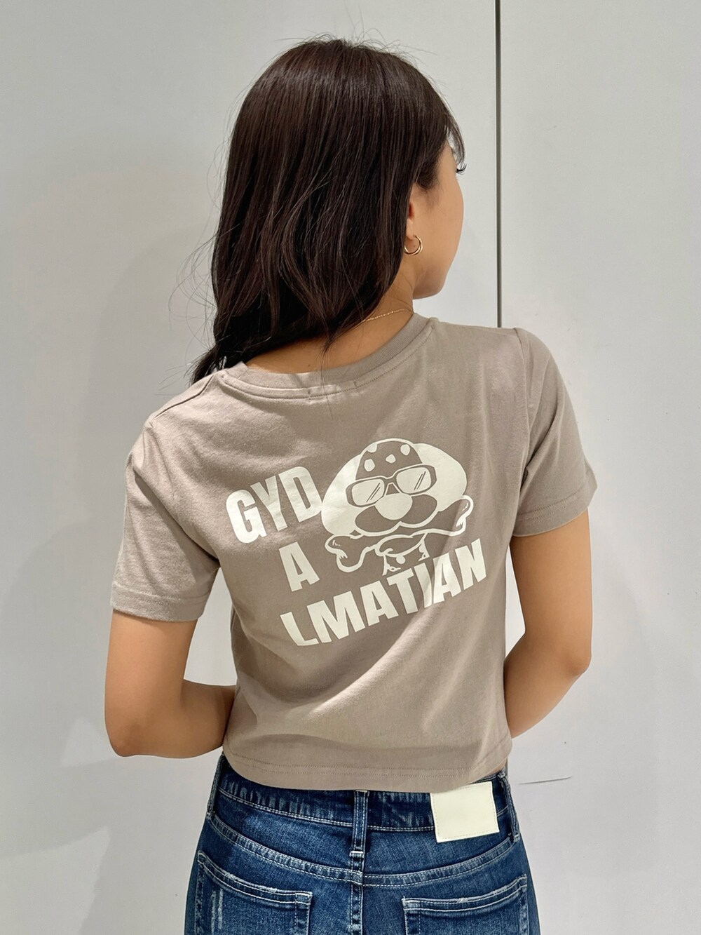 ベージュ系のTシャツ/カットソー、ブルー系のデニムパンツ、ホワイト系のパンプスを着用したレディースの夏コーディネートの6枚目の写真