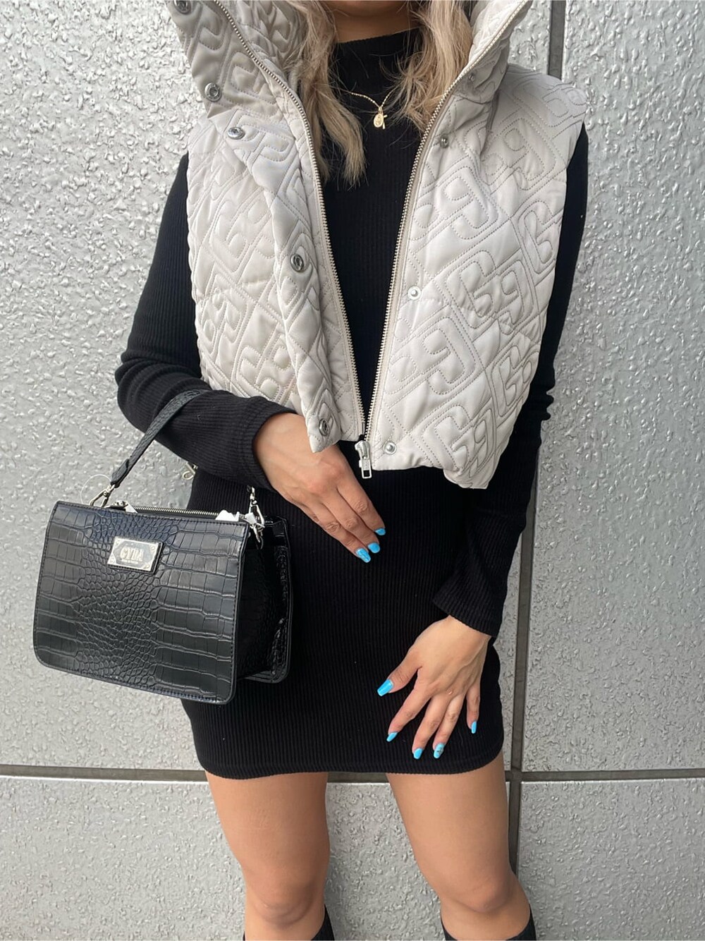 ブラック系のハンドバッグ、ブラック系のワンピース、ブラック系のブーツを着用したレディースの秋コーディネートの5枚目の写真