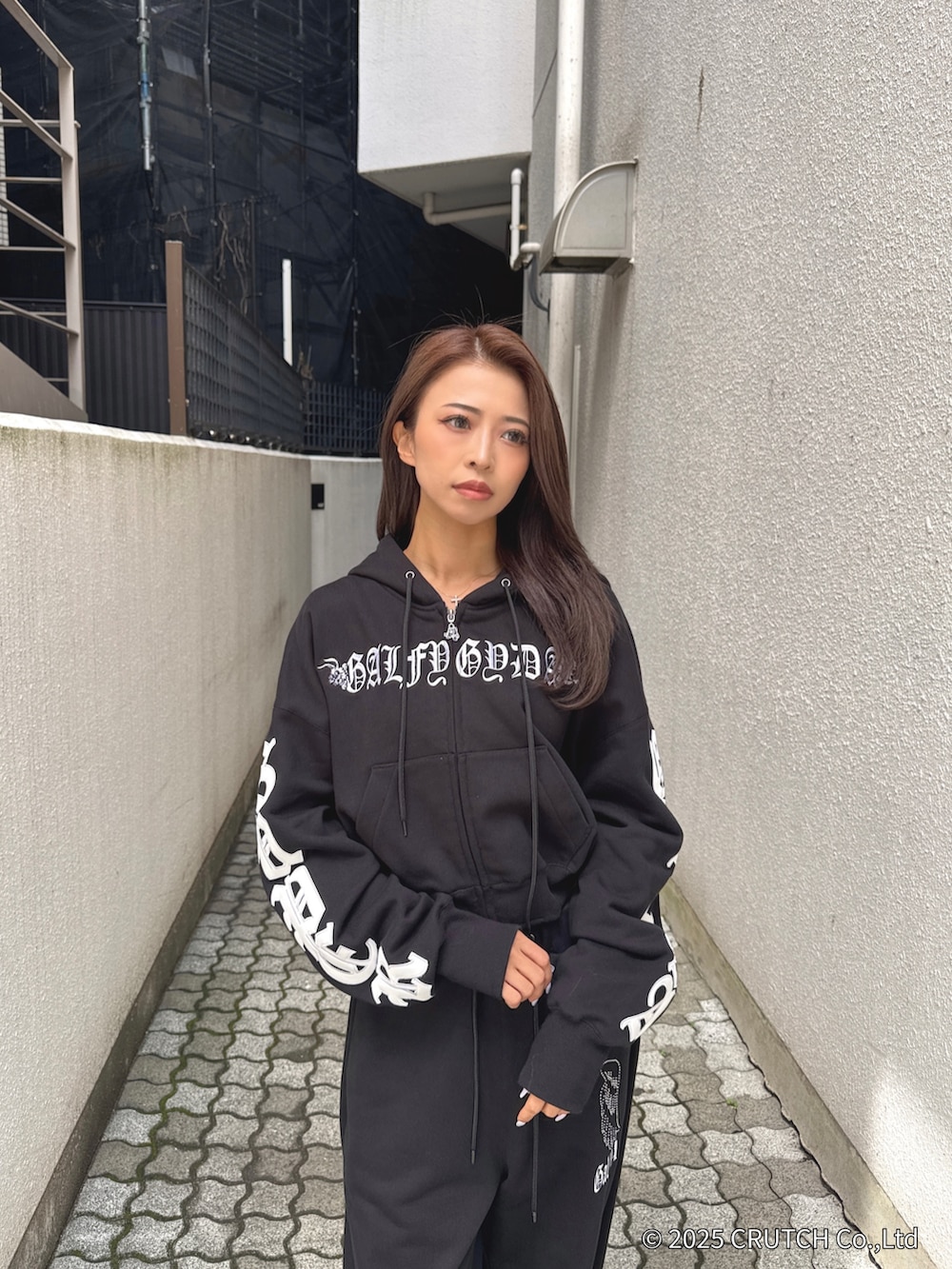 ブラック系のパーカー、ブラック系のその他パンツ、ホワイト系のパンプスを着用したレディースの秋コーディネートの5枚目の写真