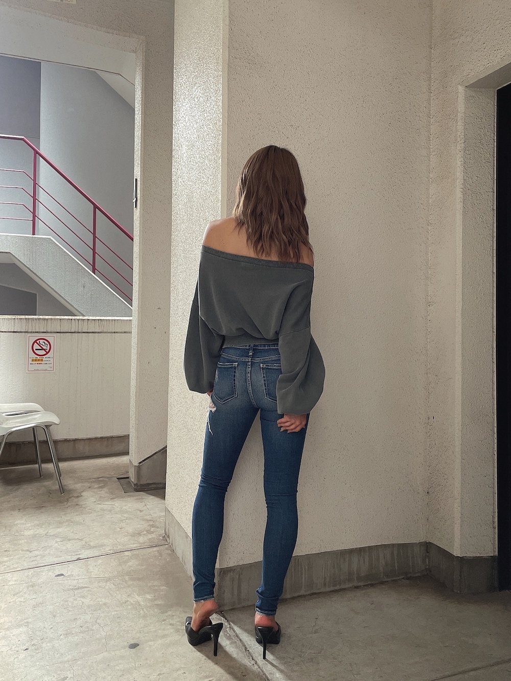 グレー系のスウェット、ブルー系のデニムパンツ、ブラック系のパンプスを着用したレディースの夏コーディネートの3枚目の写真