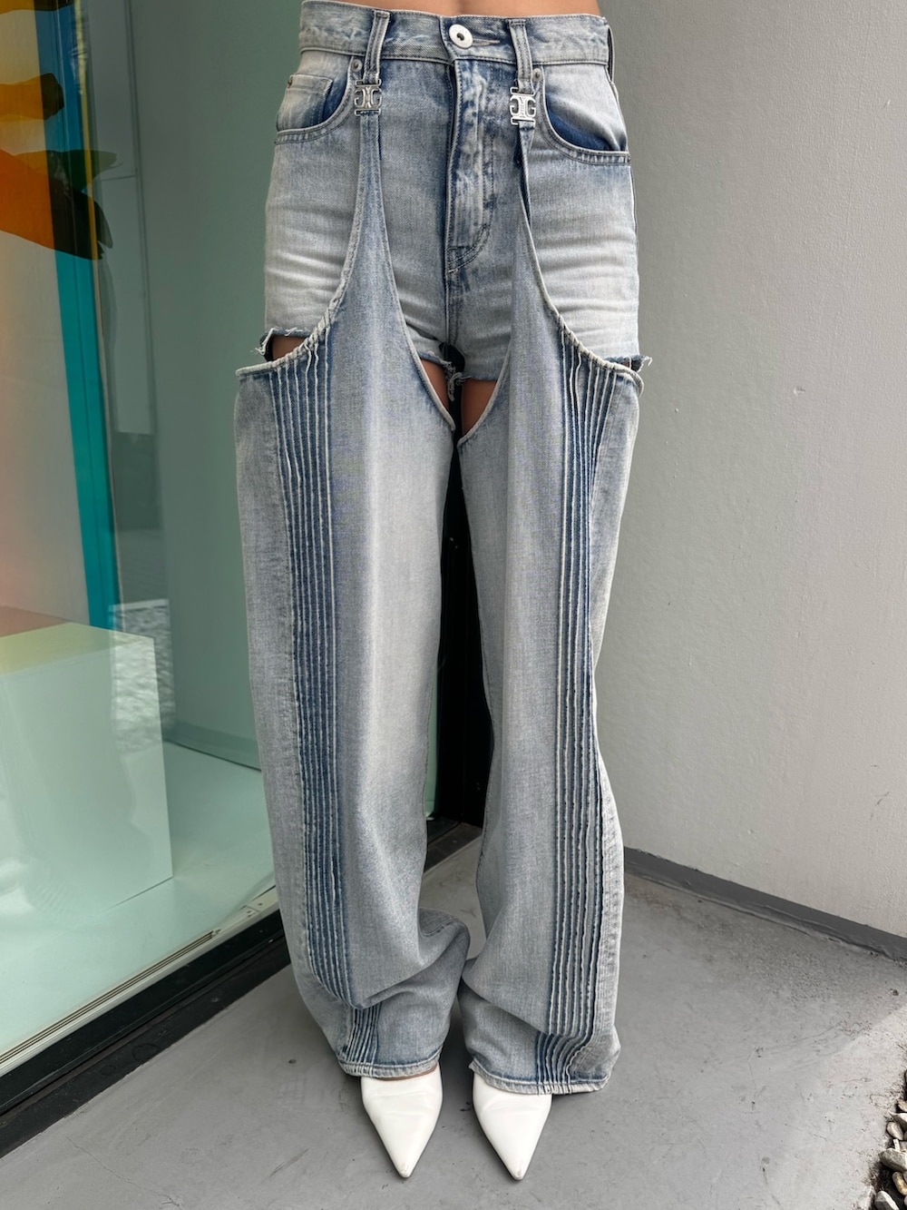 オレンジ系のニット/セーター、ブルー系のデニムパンツ、ホワイト系のパンプスを着用したレディースの春コーディネートの7枚目の写真