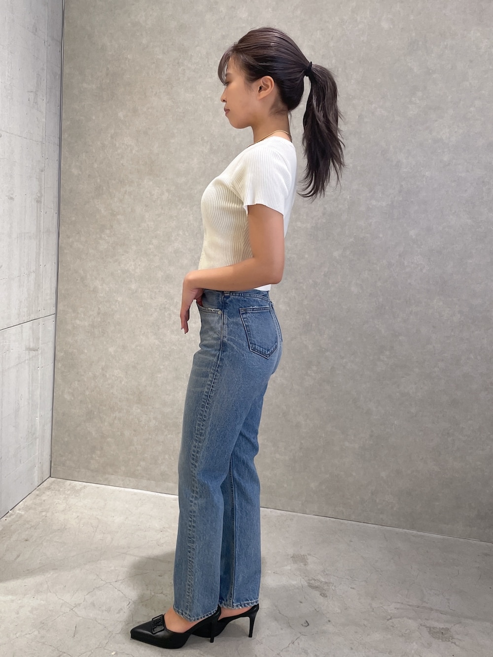 ブルー系のデニムパンツ、ブラック系のパンプス、ホワイト系のTシャツ/カットソーを着用したレディースの春コーディネートの3枚目の写真
