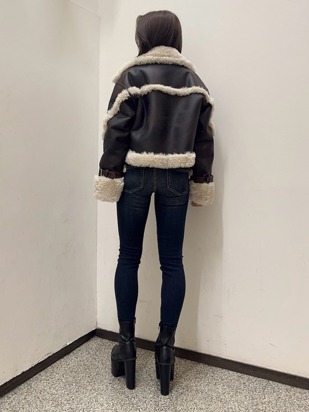 ホワイト系のTシャツ/カットソー、ブラウン系のムートンコート、ブルー系のデニムパンツを着用したレディースの秋コーディネートの4枚目の写真