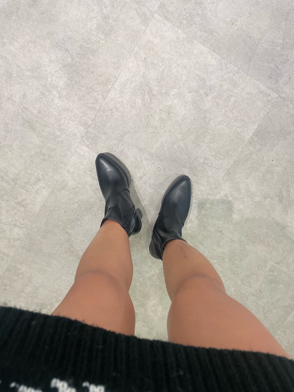 ブラック系のニット/セーター、ブラック系のブーツを着用したレディースの冬コーディネートの7枚目の写真