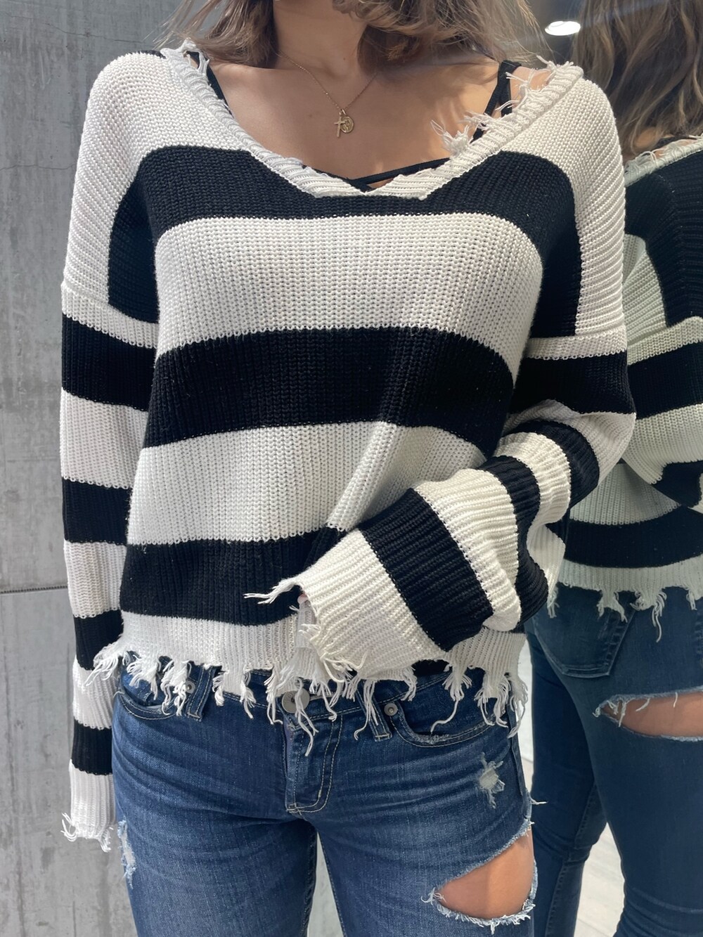 ブルー系のデニムパンツ、ホワイト系のパンプス、ブラック系のニット/セーターを着用したレディースの冬コーディネートの4枚目の写真