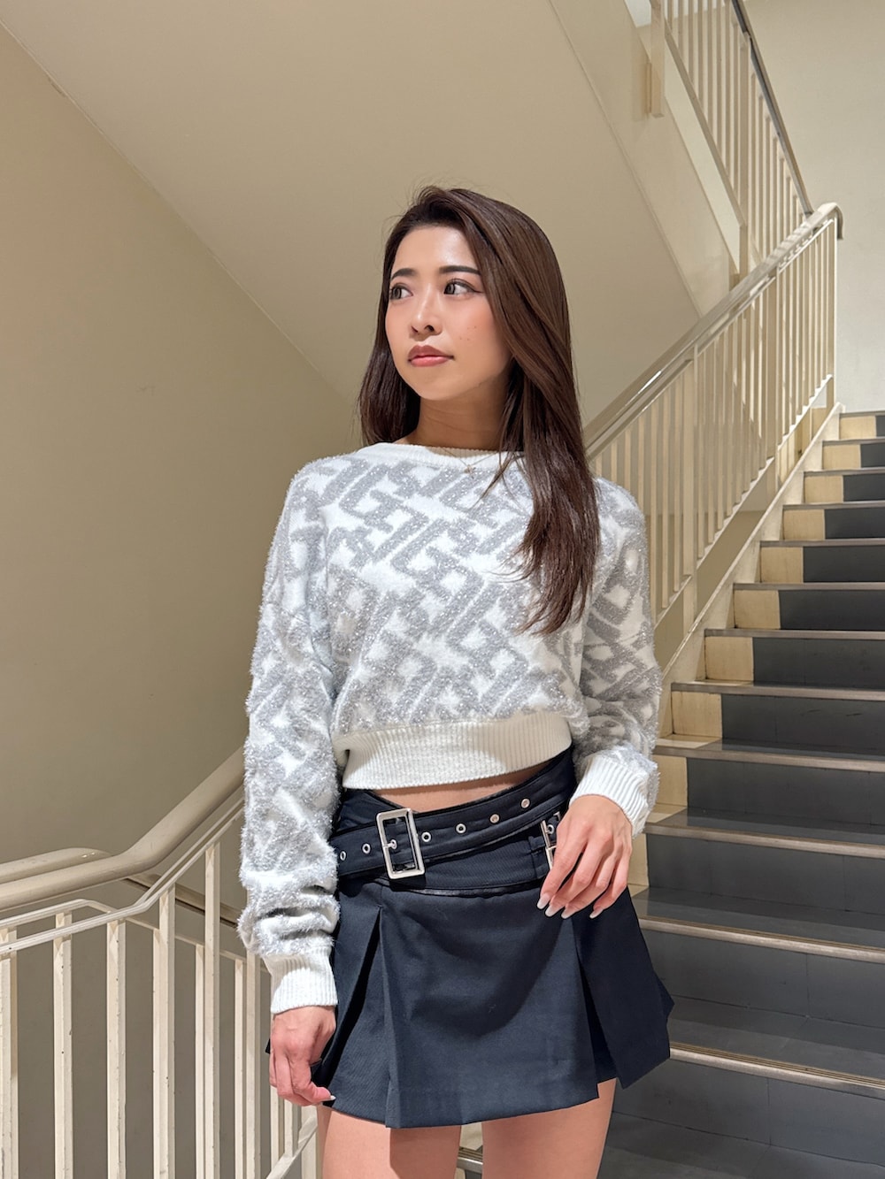 ホワイト系のニット/セーター、ブラック系のスカート、ブラック系のブーツを着用したレディースの秋コーディネートの5枚目の写真