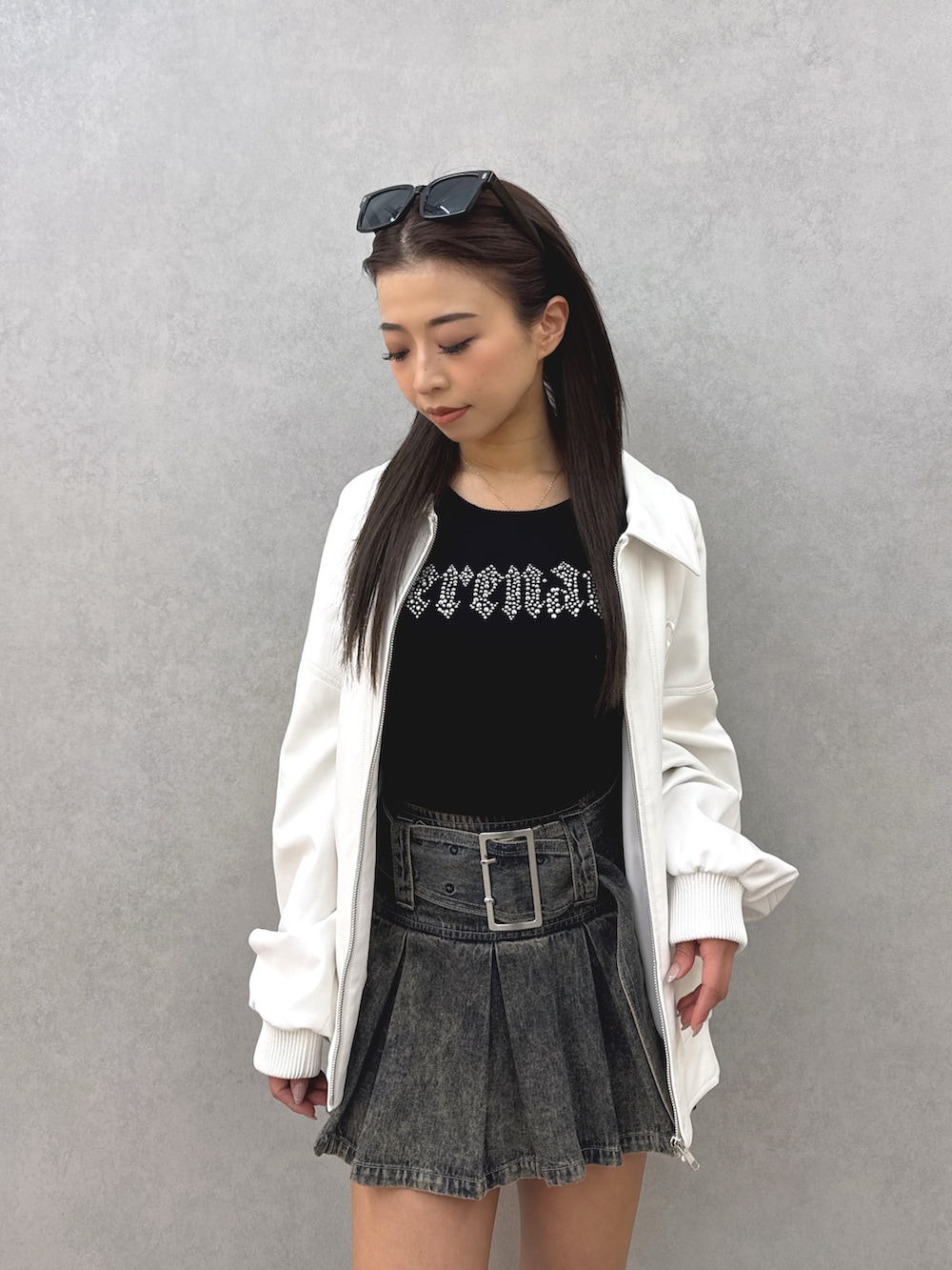 ブルー系のデニムスカート、ブラック系のブーツ、ブラック系のニット/セーターを着用したレディースの春コーディネートの5枚目の写真