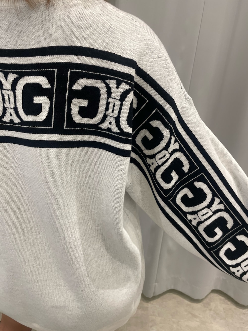 ブラック系のブーツ、ブラック系のハンドバッグ、ホワイト系のニット/セーターを着用したレディースの冬コーディネートの9枚目の写真