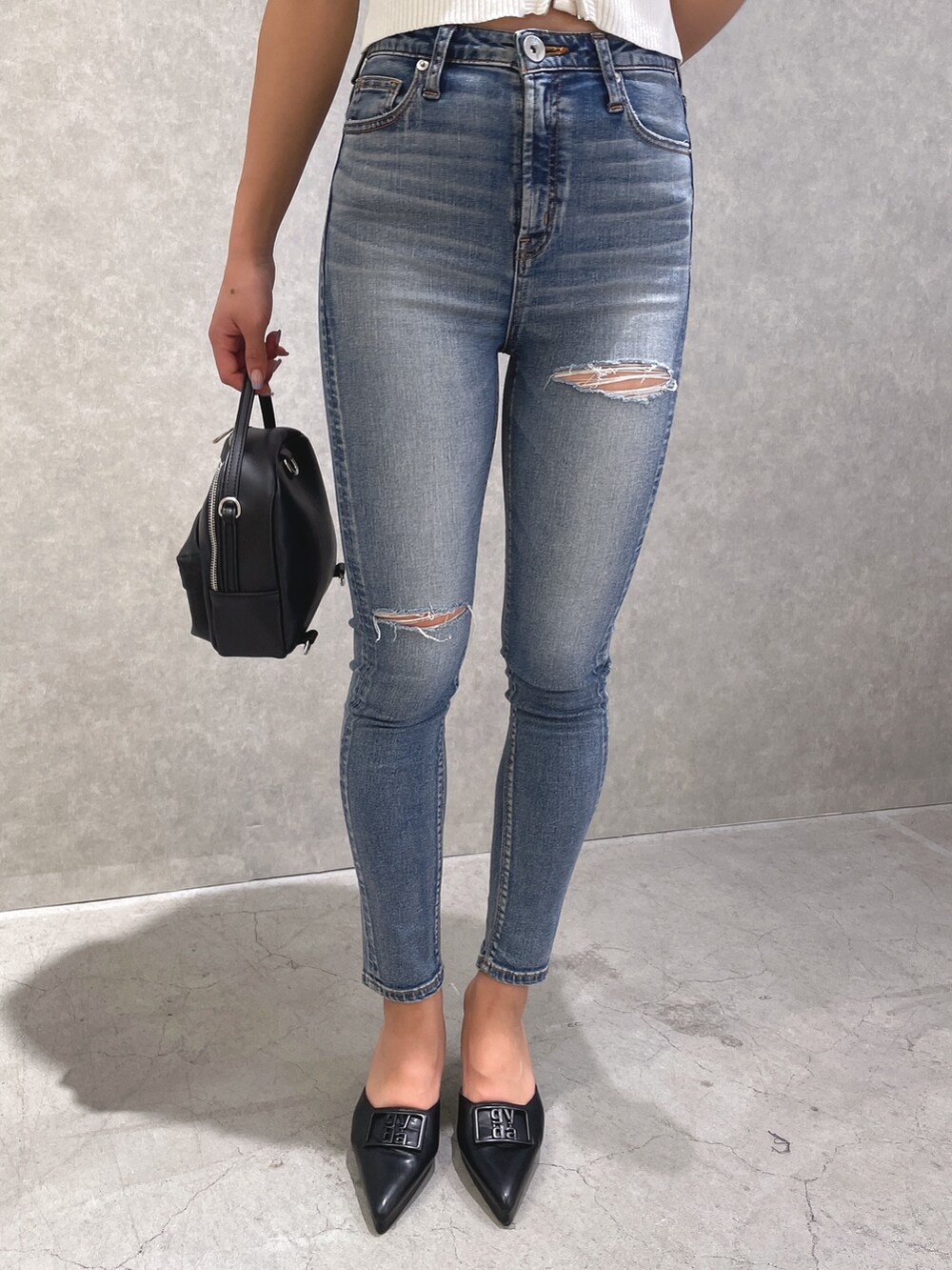 ホワイト系のTシャツ/カットソー、ブルー系のデニムパンツ、ブラック系のパンプスを着用したレディースの春コーディネートの9枚目の写真