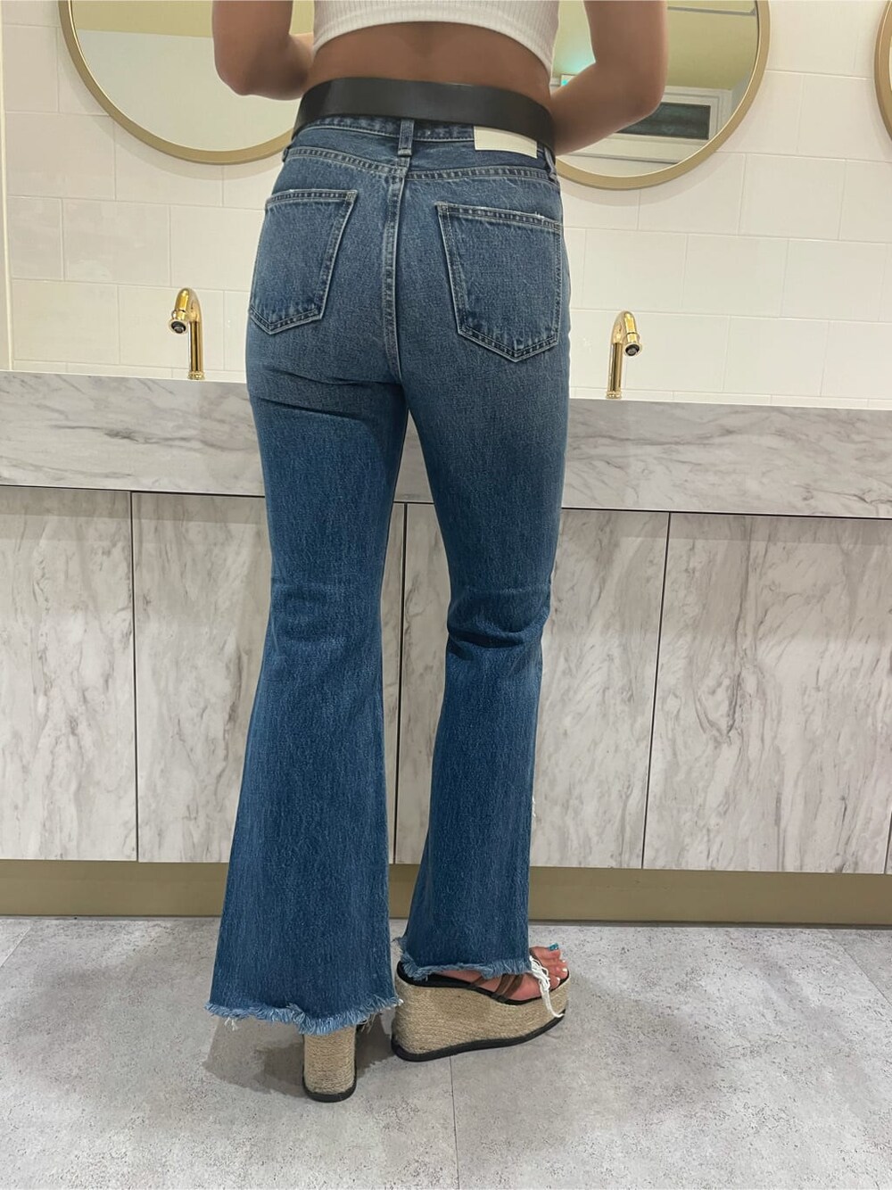 ブルー系のデニムパンツ、ホワイト系のキャミソール、ブラック系のサンダルを着用したレディースの夏コーディネートの7枚目の写真