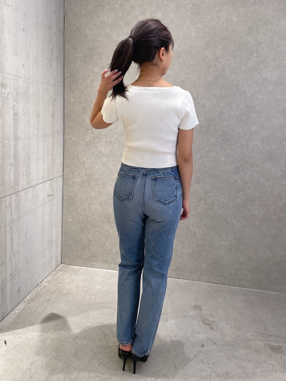 ブルー系のデニムパンツ、ブラック系のパンプス、ホワイト系のTシャツ/カットソーを着用したレディースの春コーディネートの4枚目の写真