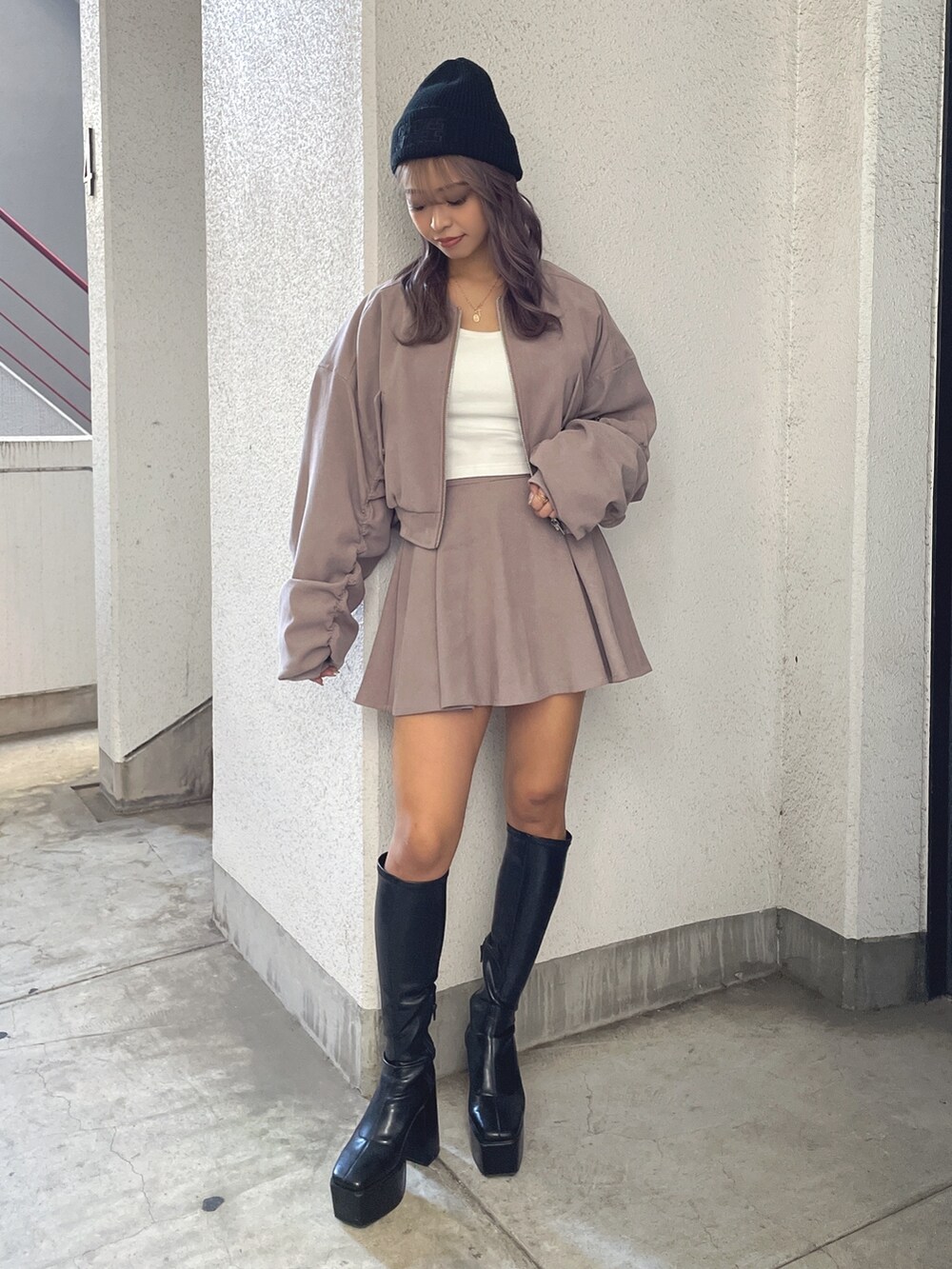 ベージュ系のブルゾン、ベージュ系のスカート、ホワイト系のTシャツ/カットソーを着用したレディースの冬コーディネートの2枚目の写真