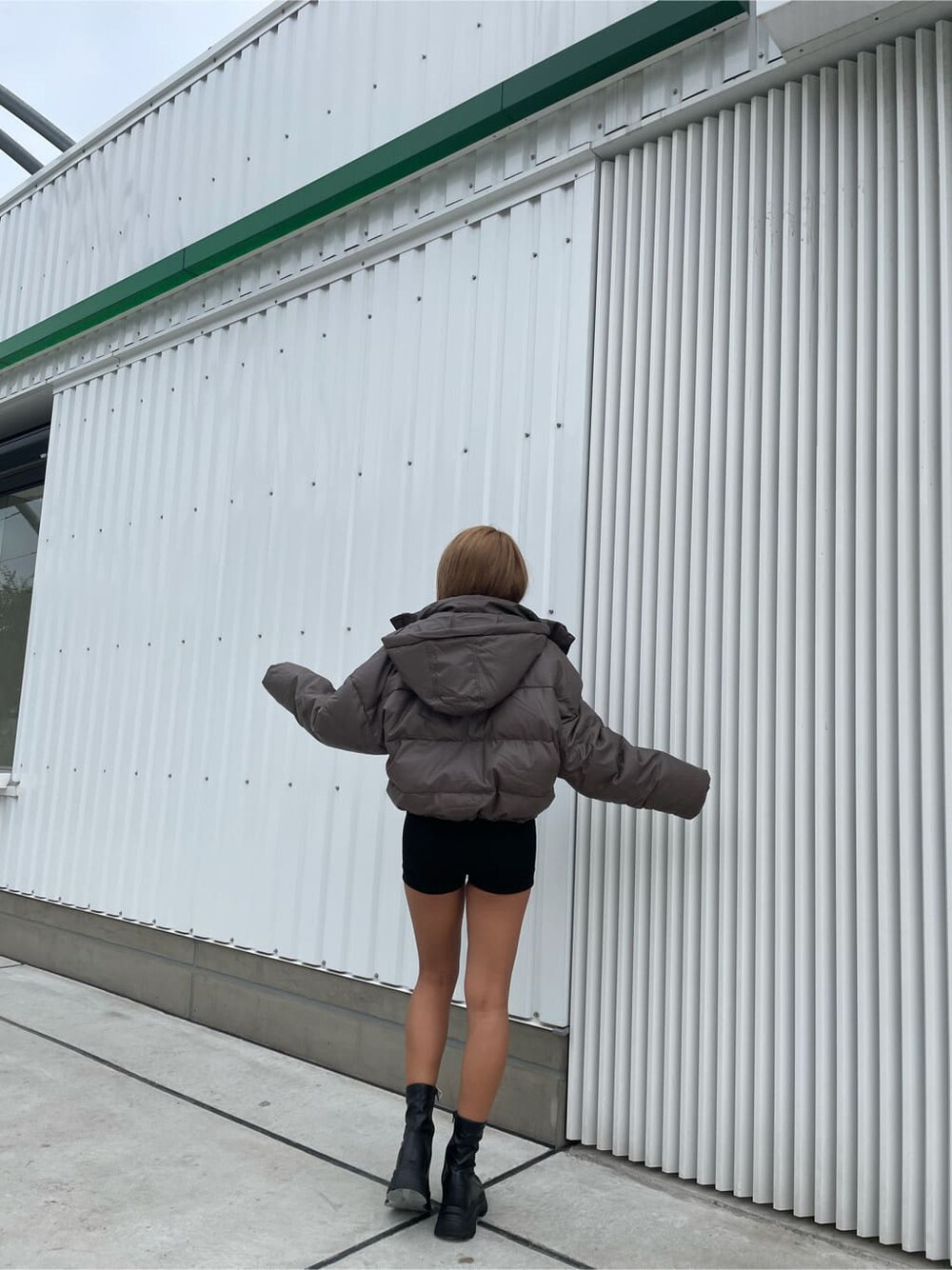 ベージュ系のダウンジャケット/コート、ブラック系のデニムパンツ、ブラック系のブーツを着用したレディースの秋コーディネートの3枚目の写真