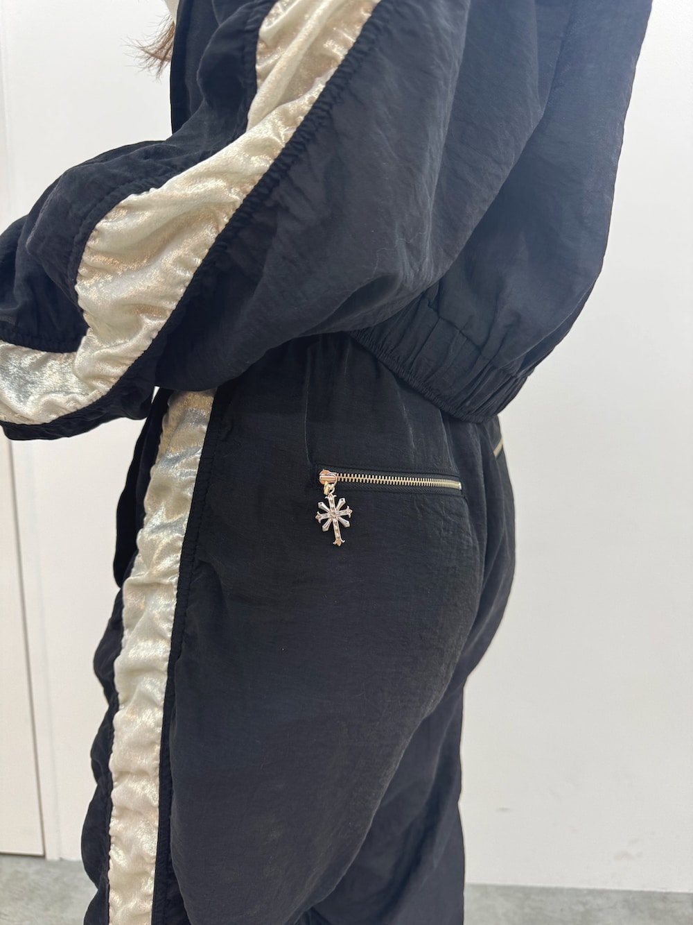 ホワイト系のチューブトップ、ブラック系のブルゾン、ブラック系のその他パンツを着用したレディースの春コーディネートの7枚目の写真