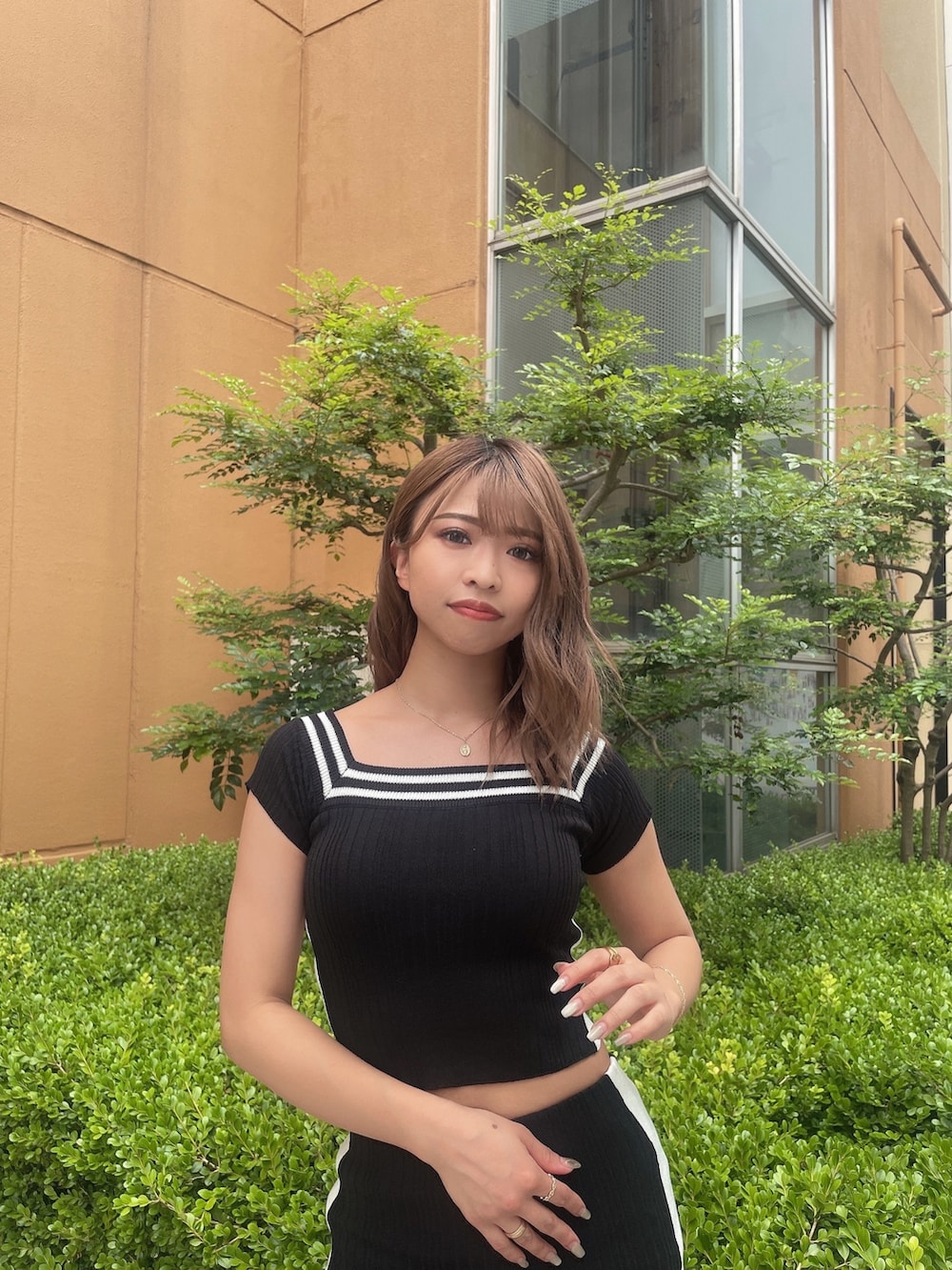 ブラック系のニット/セーター、ブラック系のスカート、ブラック系のサンダルを着用したレディースの夏コーディネートの5枚目の写真