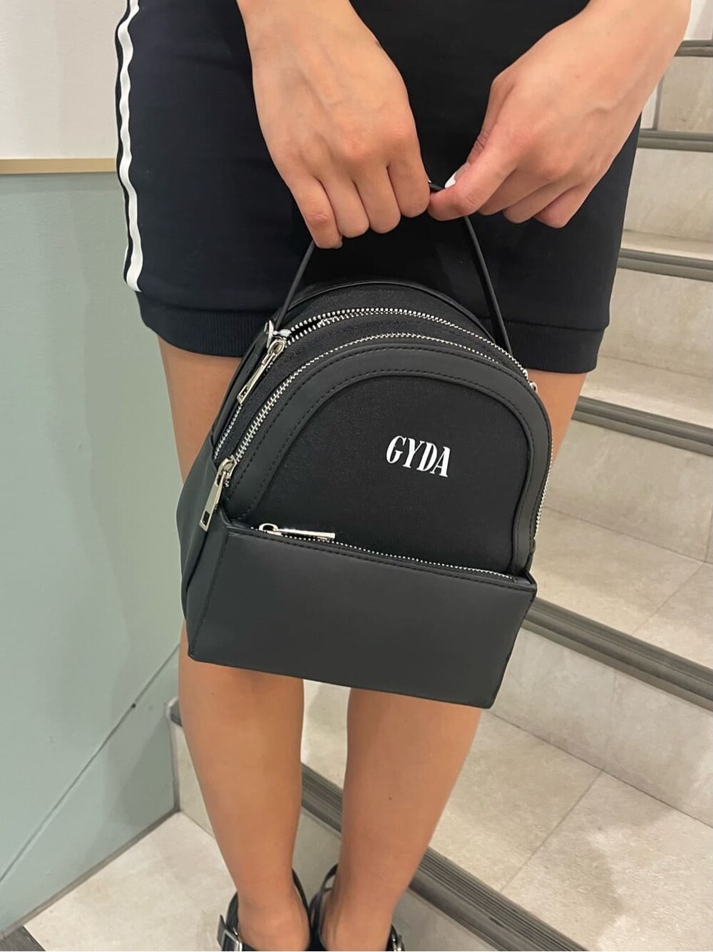 ブラック系のワンピース、ブラック系のサンダル、ブラック系のバックパック/リュックを着用したレディースの春コーディネートの6枚目の写真