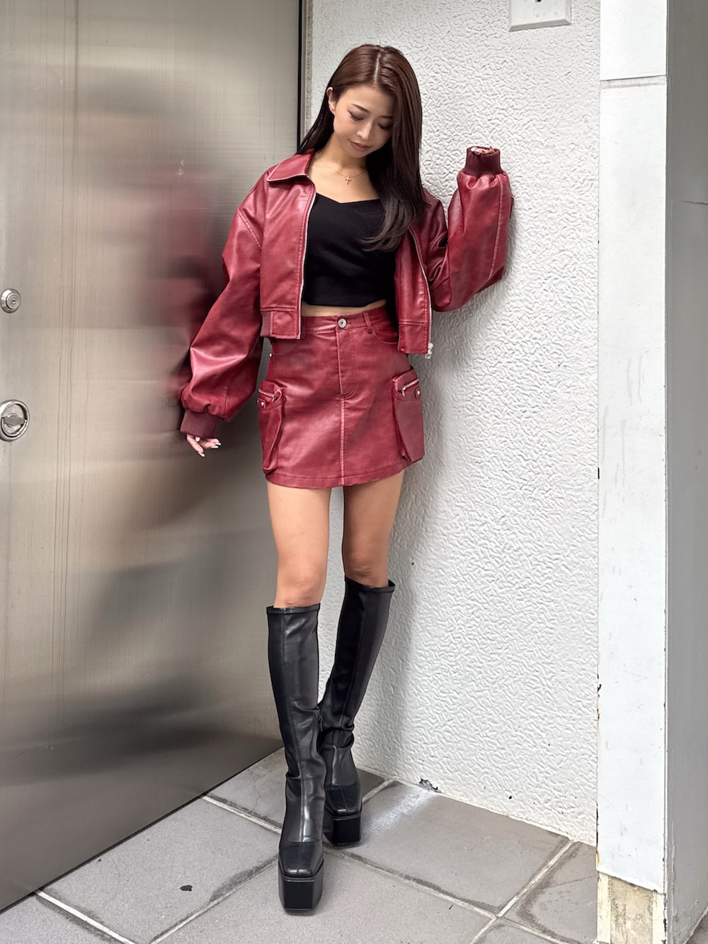 ブラック系のTシャツ/カットソー、レッド系のブルゾン、レッド系のスカートを着用したレディースの秋コーディネートの2枚目の写真