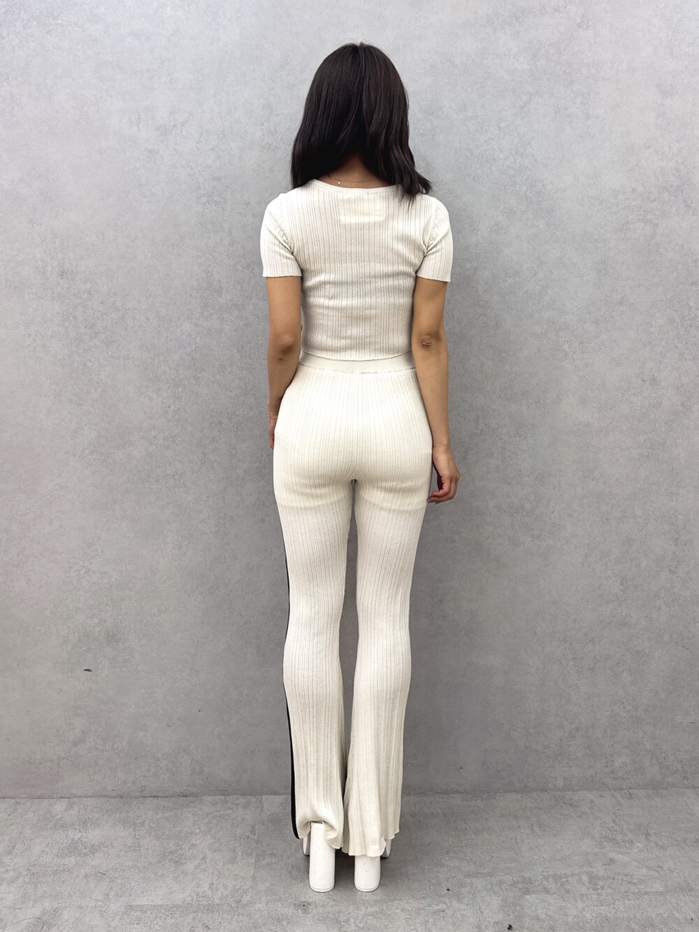 ホワイト系のニット/セーター、ホワイト系のその他パンツ、ホワイト系のサンダルを着用したレディースの夏コーディネートの4枚目の写真