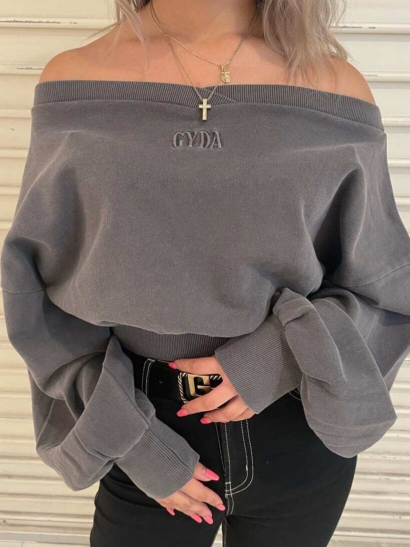 ブラック系のデニムパンツ、グレー系のスウェット、ブラック系のブーツを着用したレディースの秋コーディネートの6枚目の写真