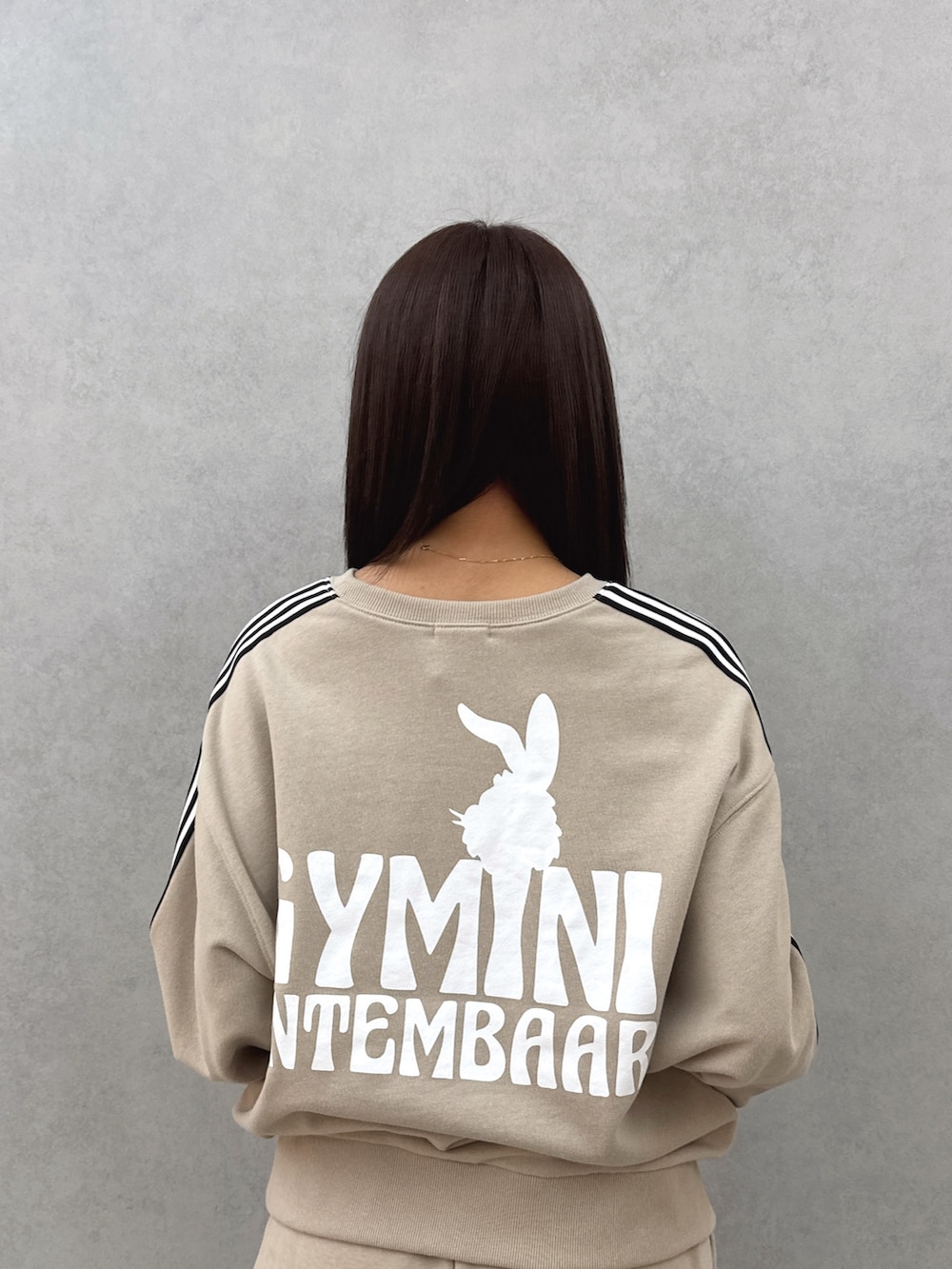 ベージュ系のスウェット、ブルー系のデニムスカート、ブラック系のブーツを着用したレディースの春コーディネートの5枚目の写真