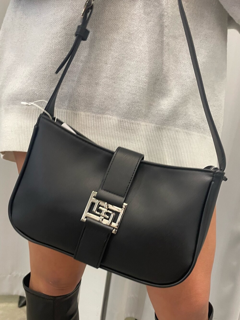 ブラック系のブーツ、ブラック系のハンドバッグ、ホワイト系のニット/セーターを着用したレディースの冬コーディネートの10枚目の写真