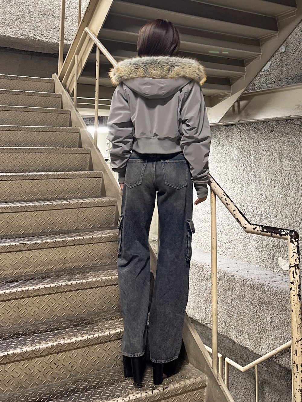 ホワイト系のTシャツ/カットソー、グレー系のブルゾン、ブルー系のデニムパンツを着用したレディースの秋コーディネートの4枚目の写真