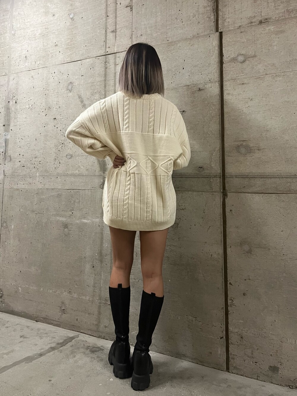 グリーン系のニット/セーター、ホワイト系のニット/セーター、ブラック系のブーツを着用したレディースの秋コーディネートの5枚目の写真