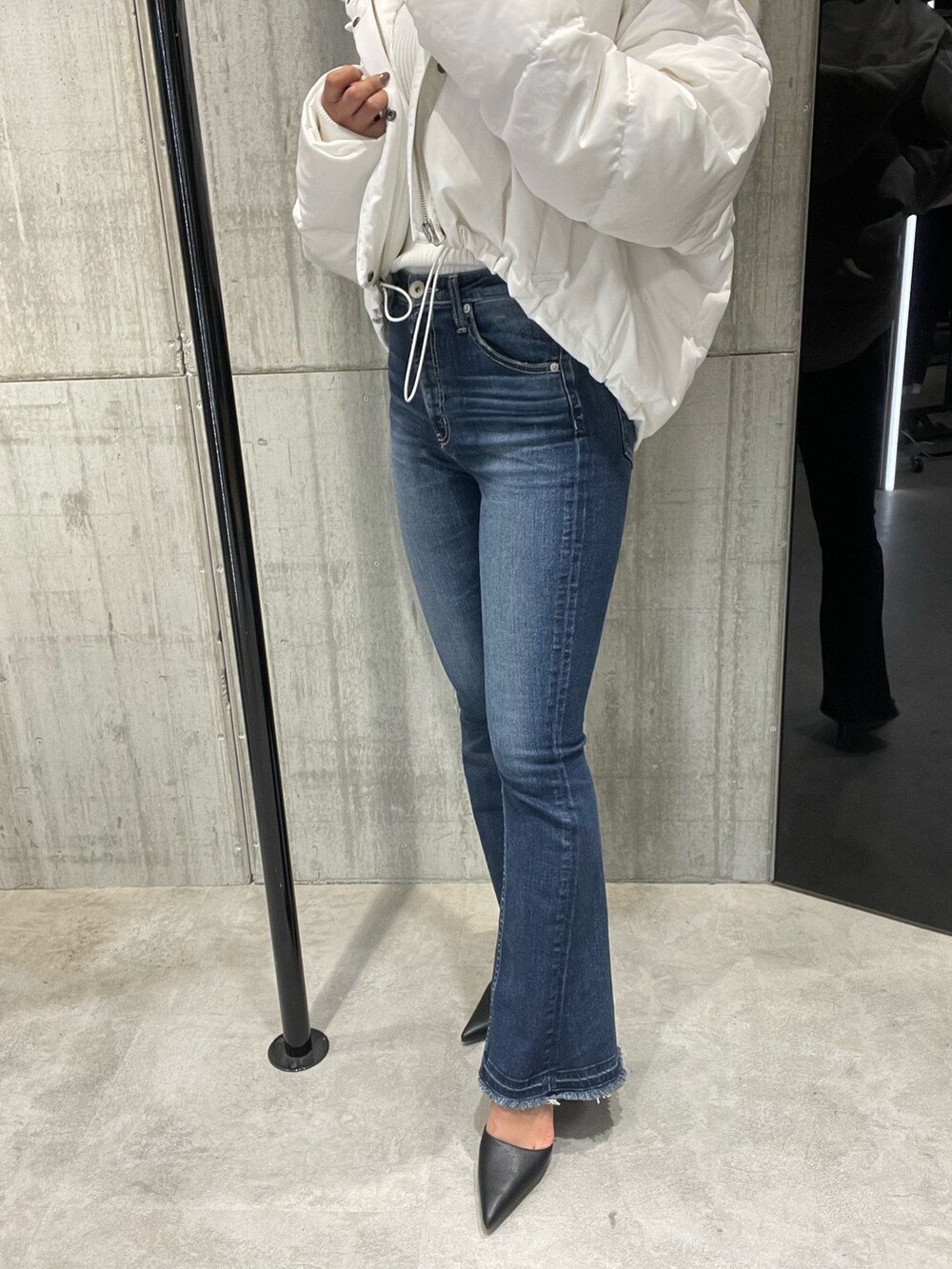 ブルー系のパンツ、ホワイト系のダウンジャケット/コート、ホワイト系のニット/セーターを着用したレディースの冬コーディネートの8枚目の写真