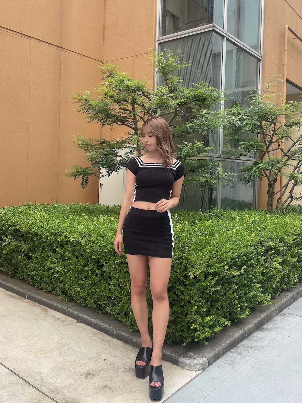 ブラック系のニット/セーター、ブラック系のスカート、ブラック系のサンダルを着用したレディースの夏コーディネートの2枚目の写真