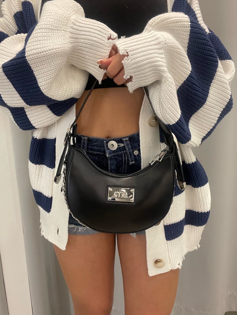 ブラック系のブーツ、ブラック系のハンドバッグ、ブルー系のデニムパンツを着用したレディースの冬コーディネートの8枚目の写真