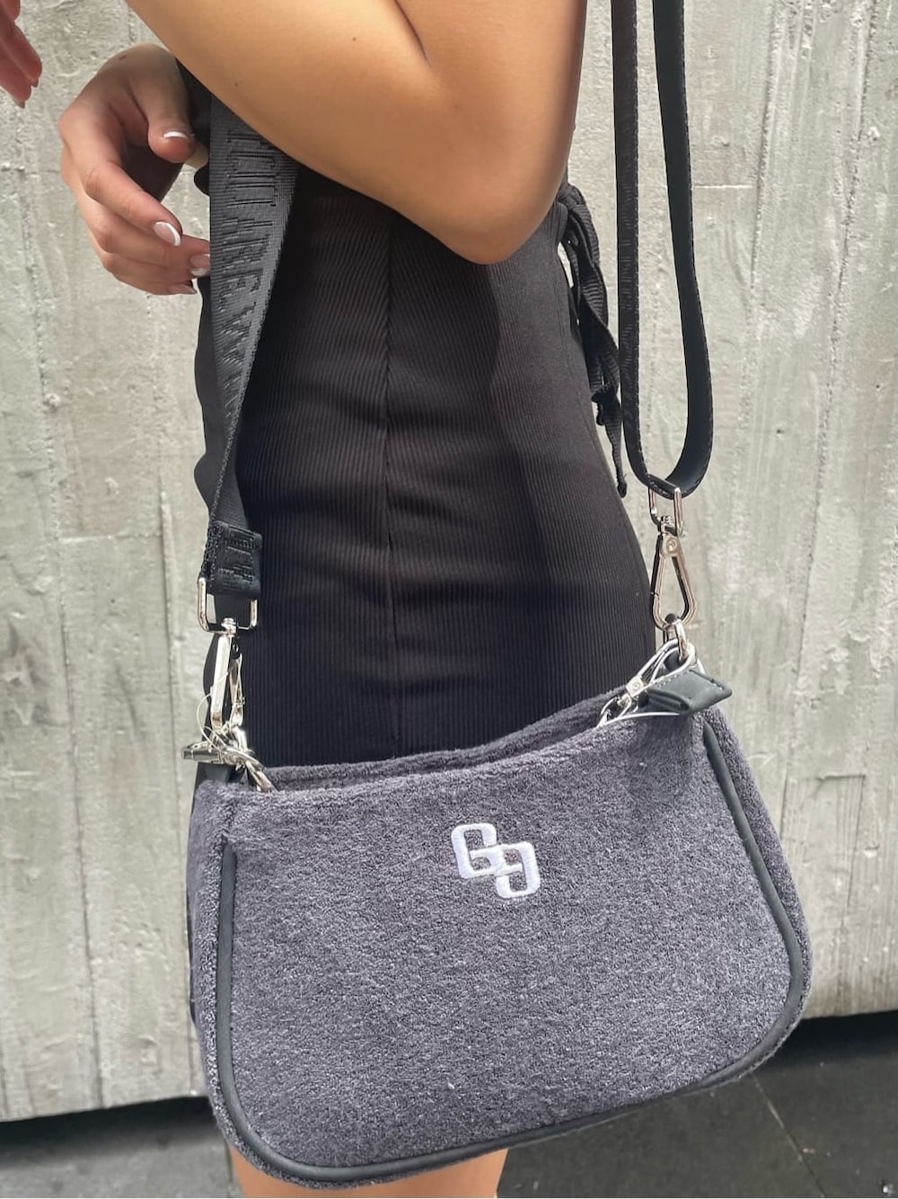 ブラック系のワンピース、グレー系のハンドバッグ、ブラック系のサンダルを着用したレディースの春コーディネートの8枚目の写真