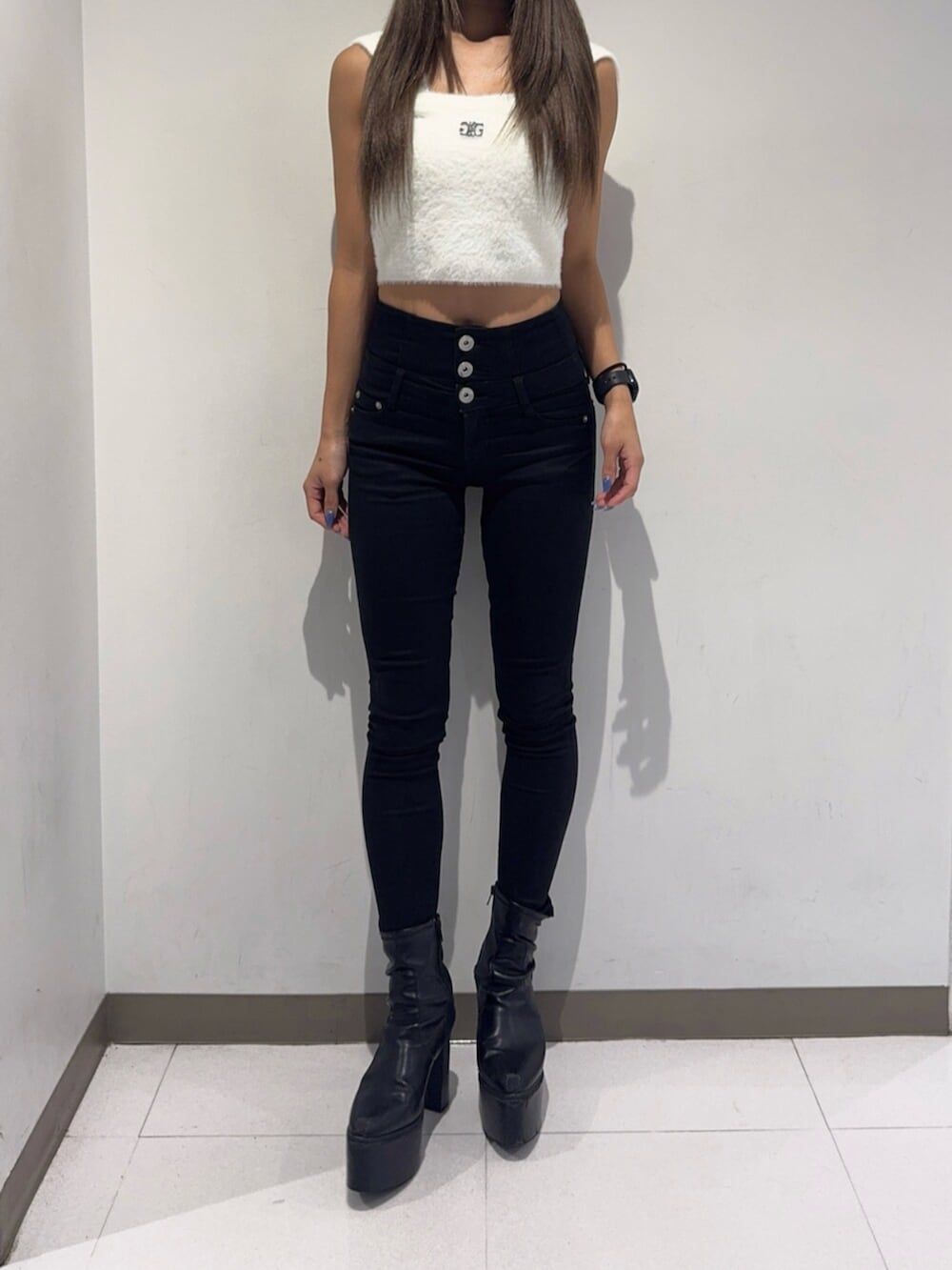 ブラック系のデニムパンツ、ブラック系のブーツ、ホワイト系のニット/セーターを着用したレディースの秋コーディネートの6枚目の写真