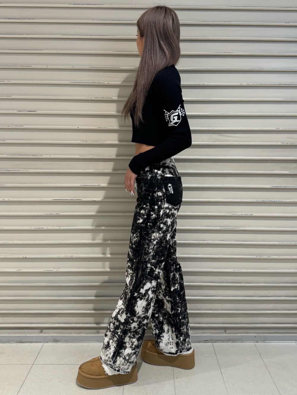 ブラック系のニット/セーター、ブラック系のデニムパンツ、ベージュ系のブーツを着用したレディースの秋コーディネートの2枚目の写真