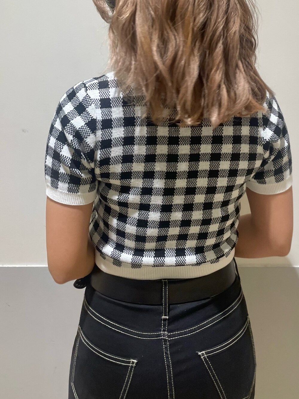 ホワイト系のハンドバッグ、ブラック系のデニムパンツ、ブラック系のカーディガン/ボレロを着用したレディースの春コーディネートの6枚目の写真