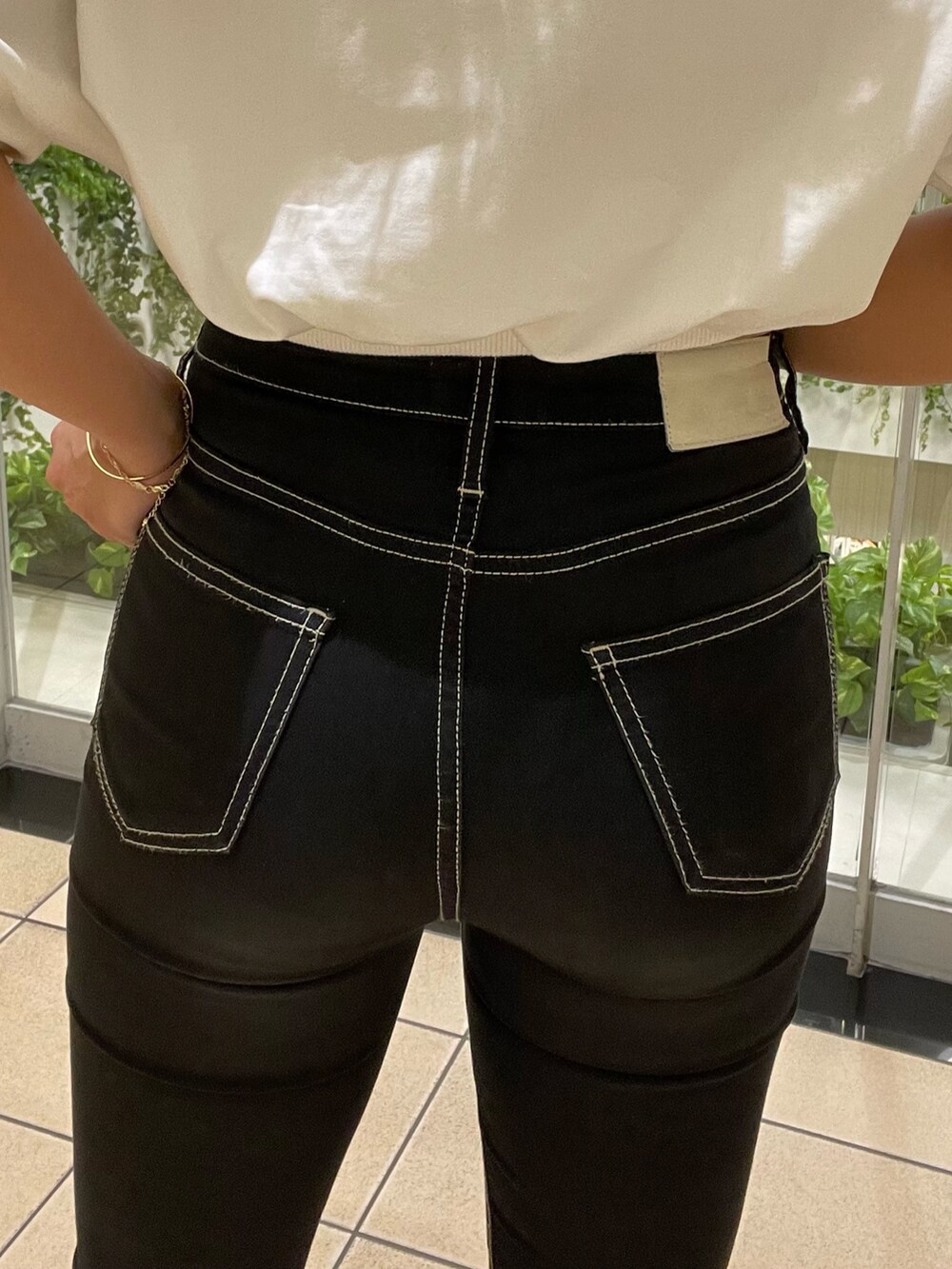 ホワイト系のTシャツ/カットソー、ブラック系のデニムパンツ、ホワイト系のパンプスを着用したレディースの春コーディネートの8枚目の写真