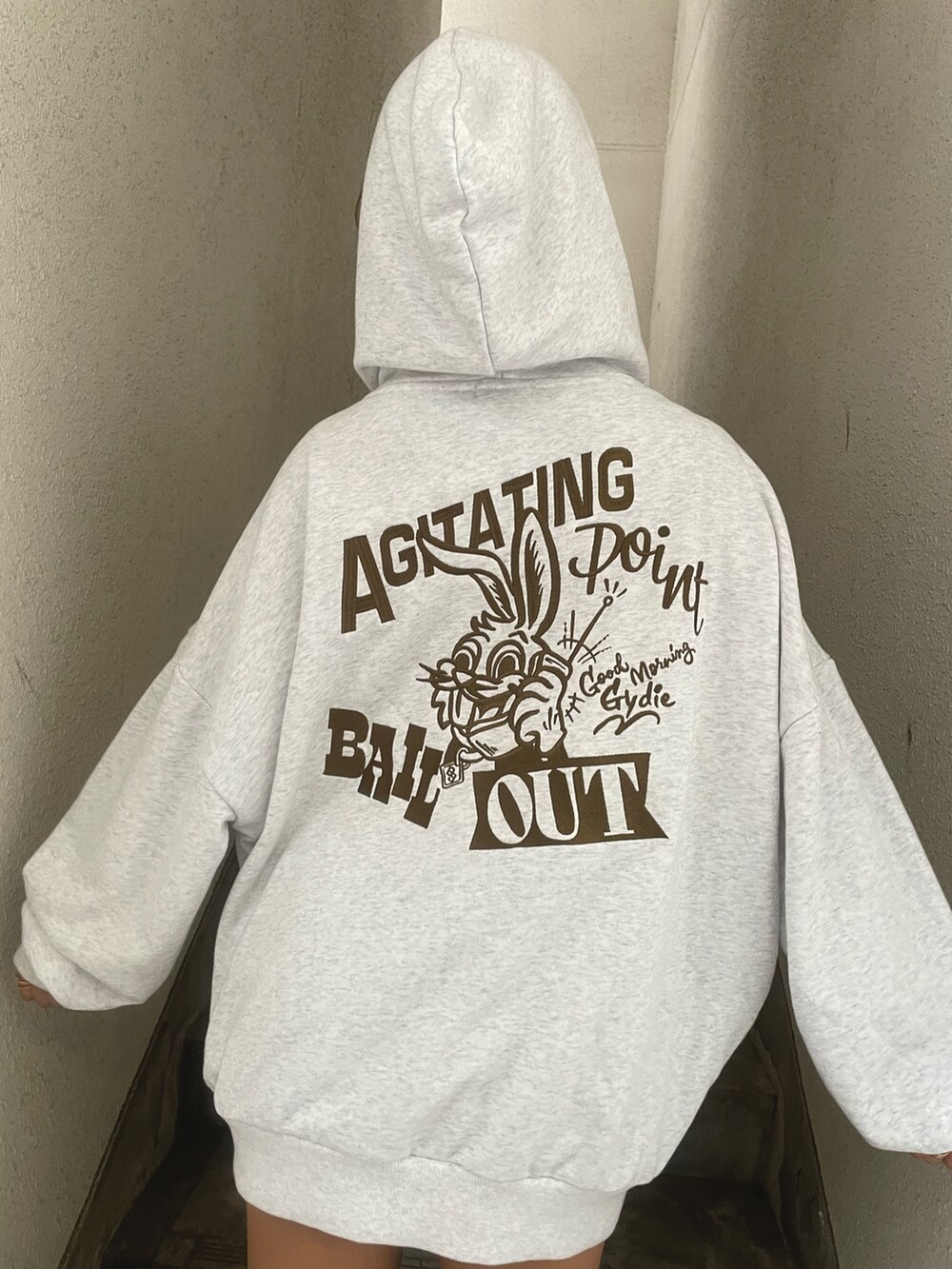 グレー系のスウェット、ブルー系のデニムスカート、ブラック系のブーツを着用したレディースの秋コーディネートの6枚目の写真