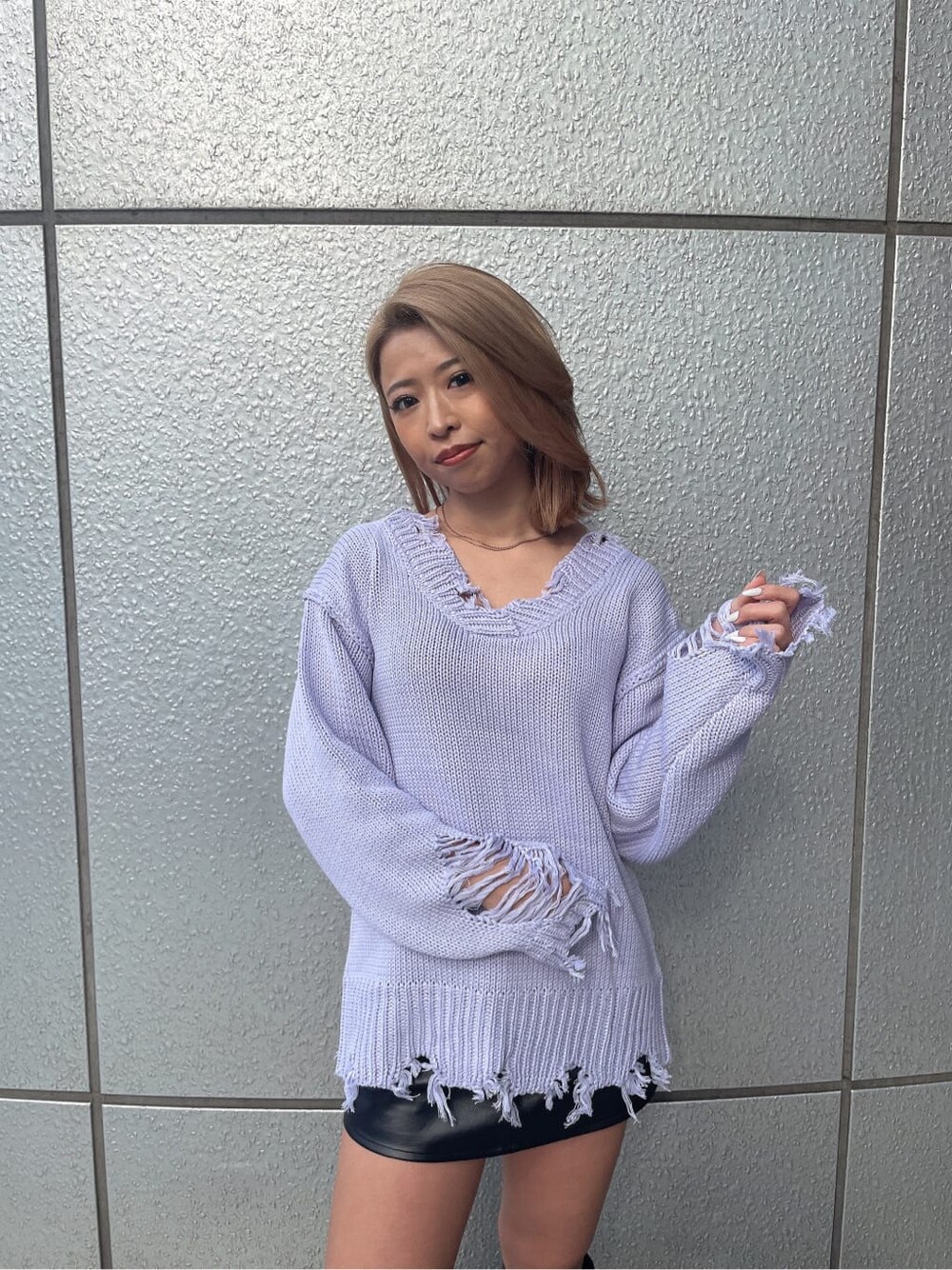 パープル系のニット/セーター、グレー系のハンドバッグ、ブラック系のブーツを着用したレディースの冬コーディネートの4枚目の写真