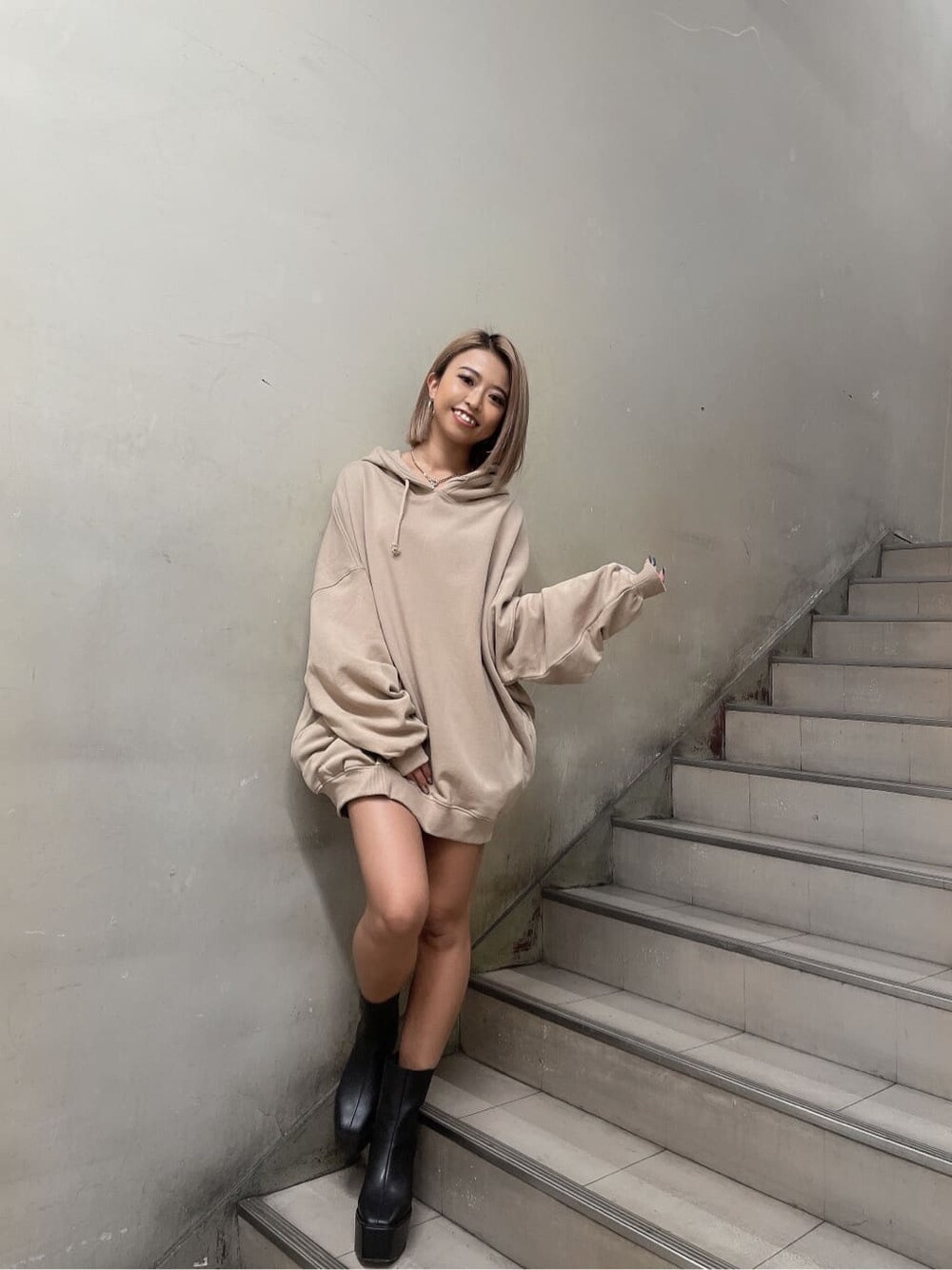 ブラック系のブーツ、ベージュ系のパーカー、ゴールド系のネックレスを着用したレディースの秋コーディネートの3枚目の写真